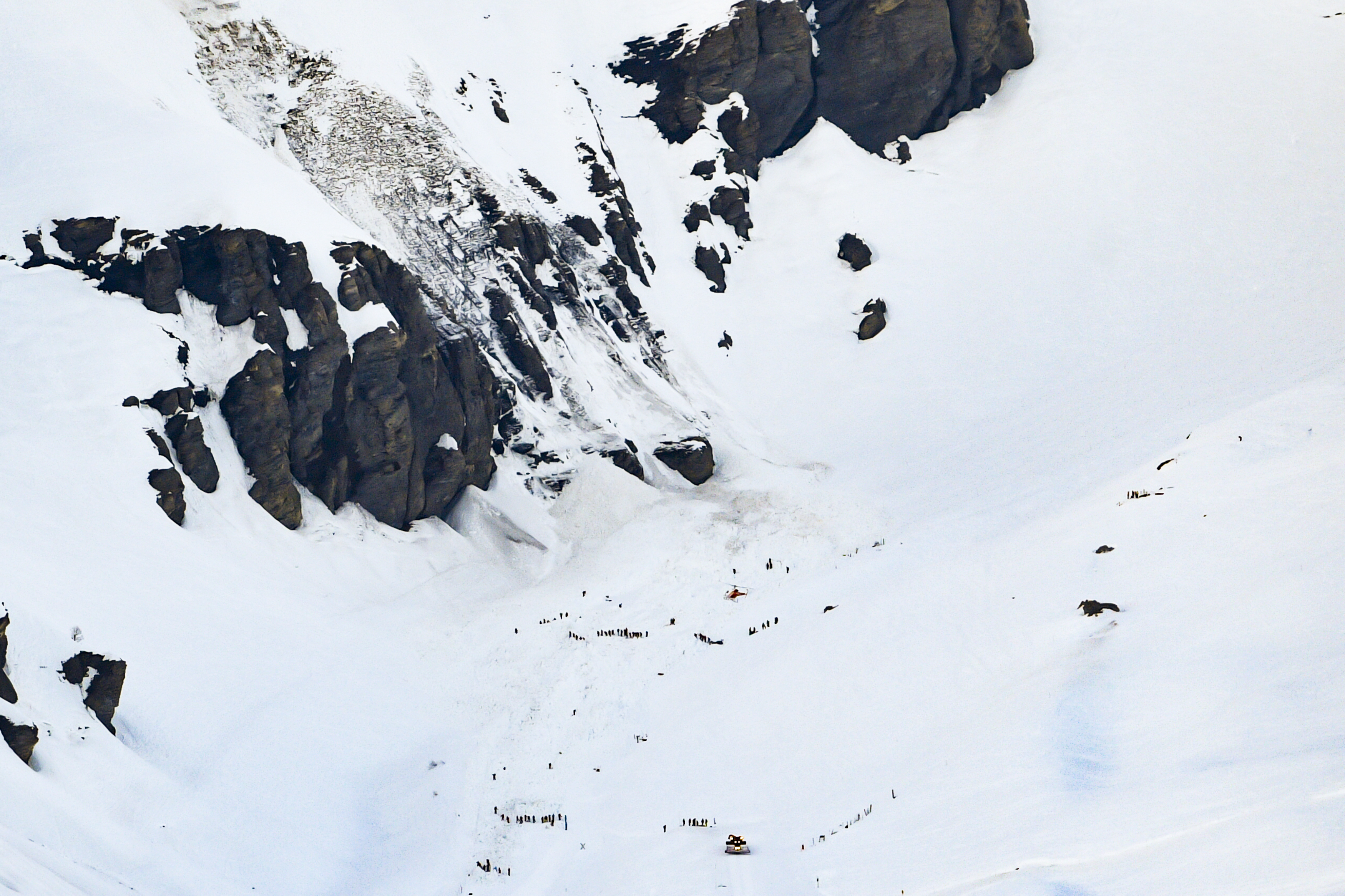 Rescue crews work on the avalanche site at the ski resort of Crans-Montana