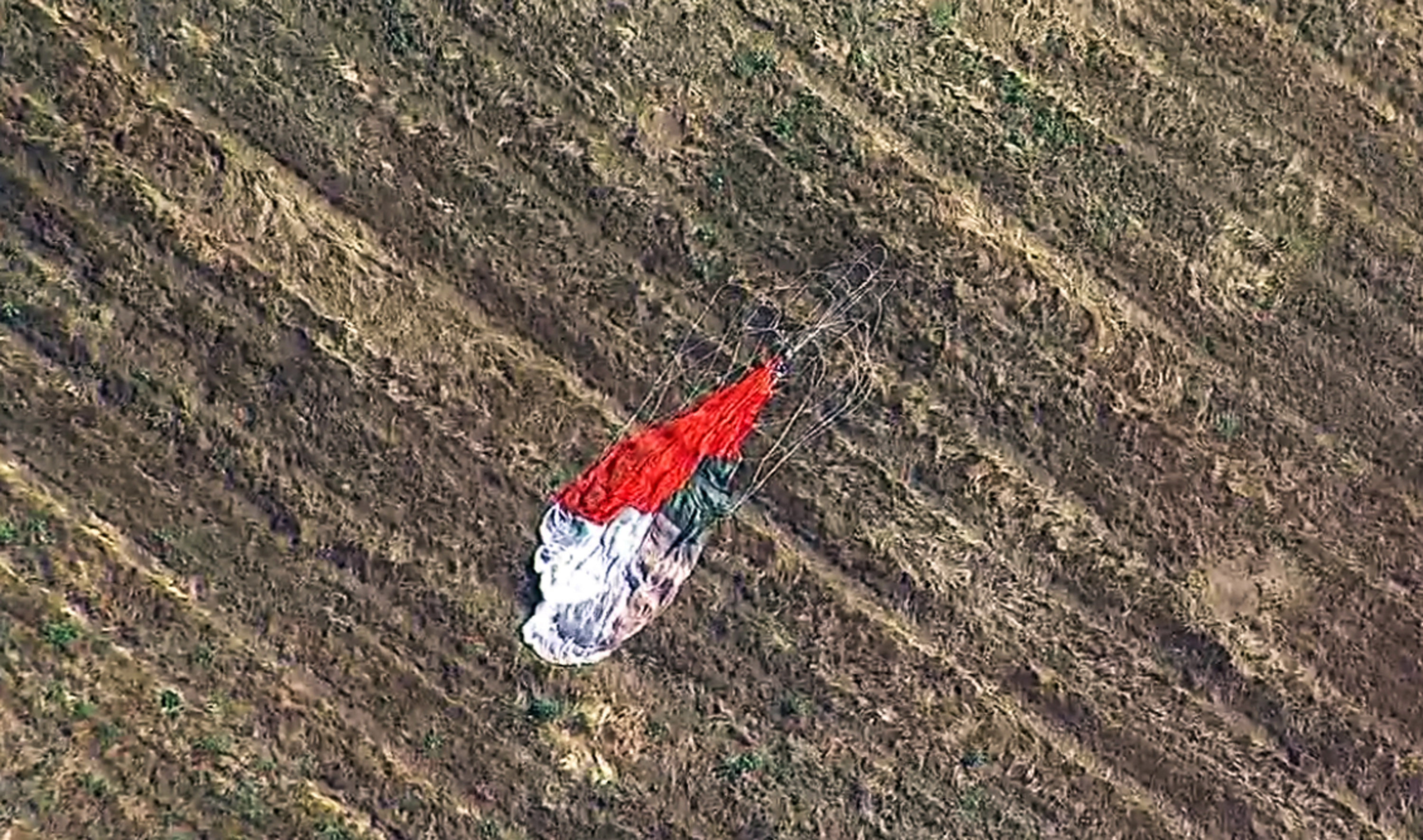 the parachute left by the pilot who ejected before his F-16 fighter jet crashed into a warehouse