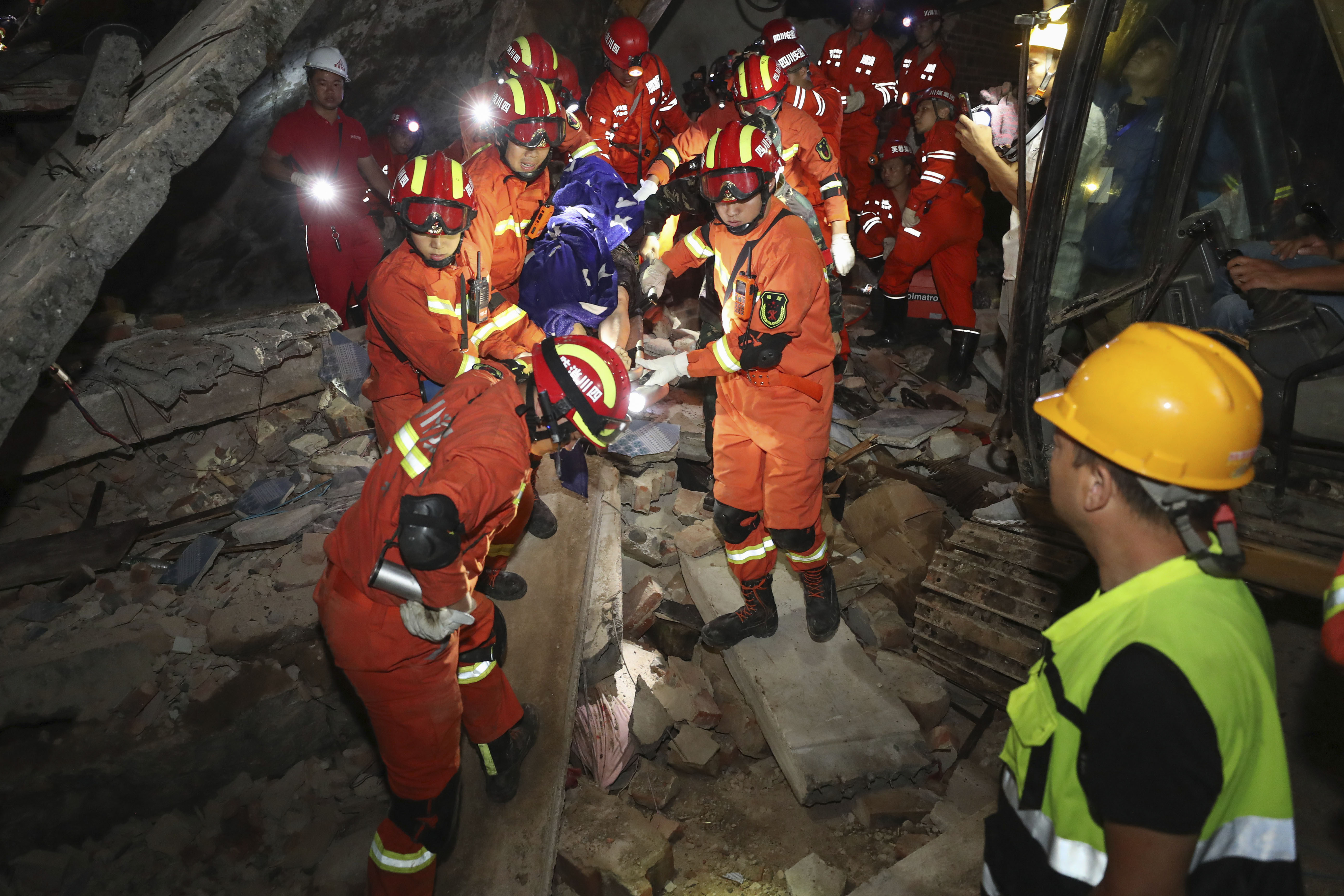 Rescue workers carry out a person from the collapsed building