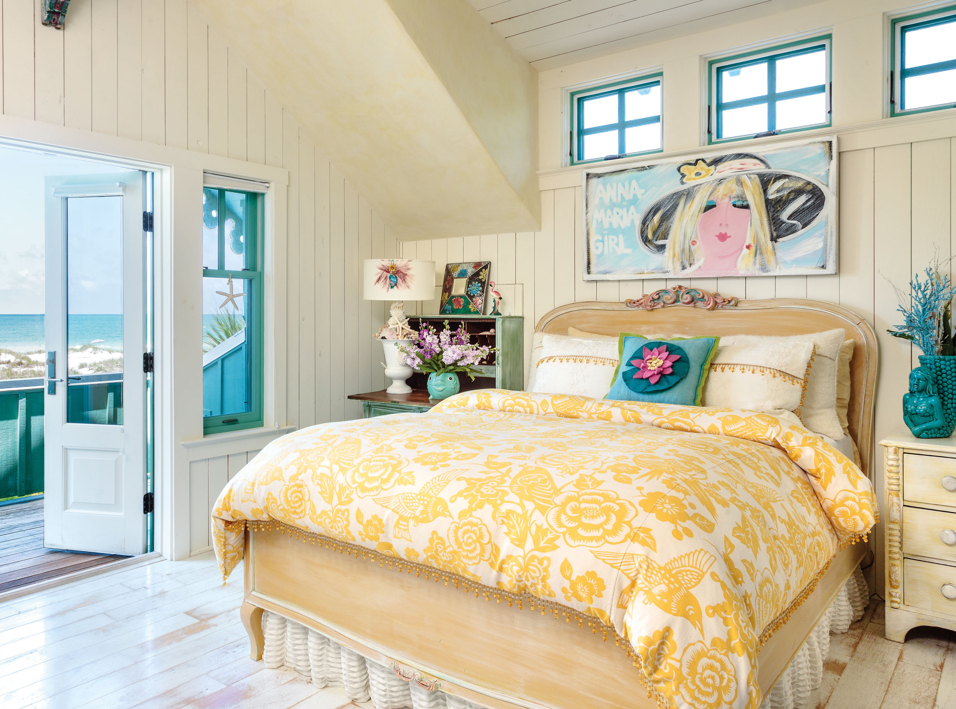 White painted floorboards and pale yellow walls and ceiling create a sunny, shore side room, while a fish shaped vase and a duvet cover decorated with hummingbirds and flowers are the perfect finishing touches in Kandice Ridley's home ( Mark Lohman/Global Bohemian/Cico Books/PA)