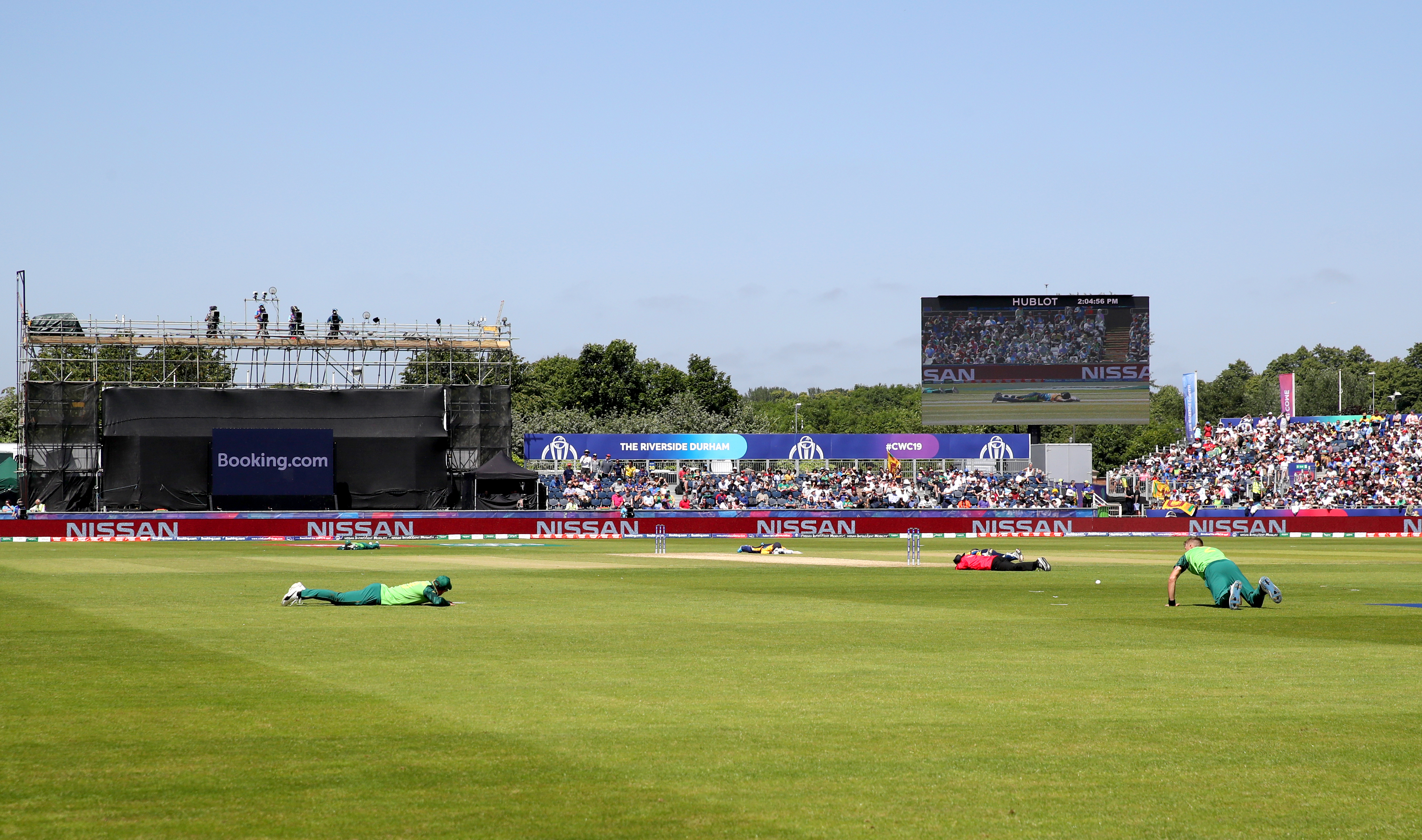 Players and umpires lie on the pitch after a swarm of bees sweeps over the ground a during the ICC Cricket World Cup group stage match at Riverside Durham