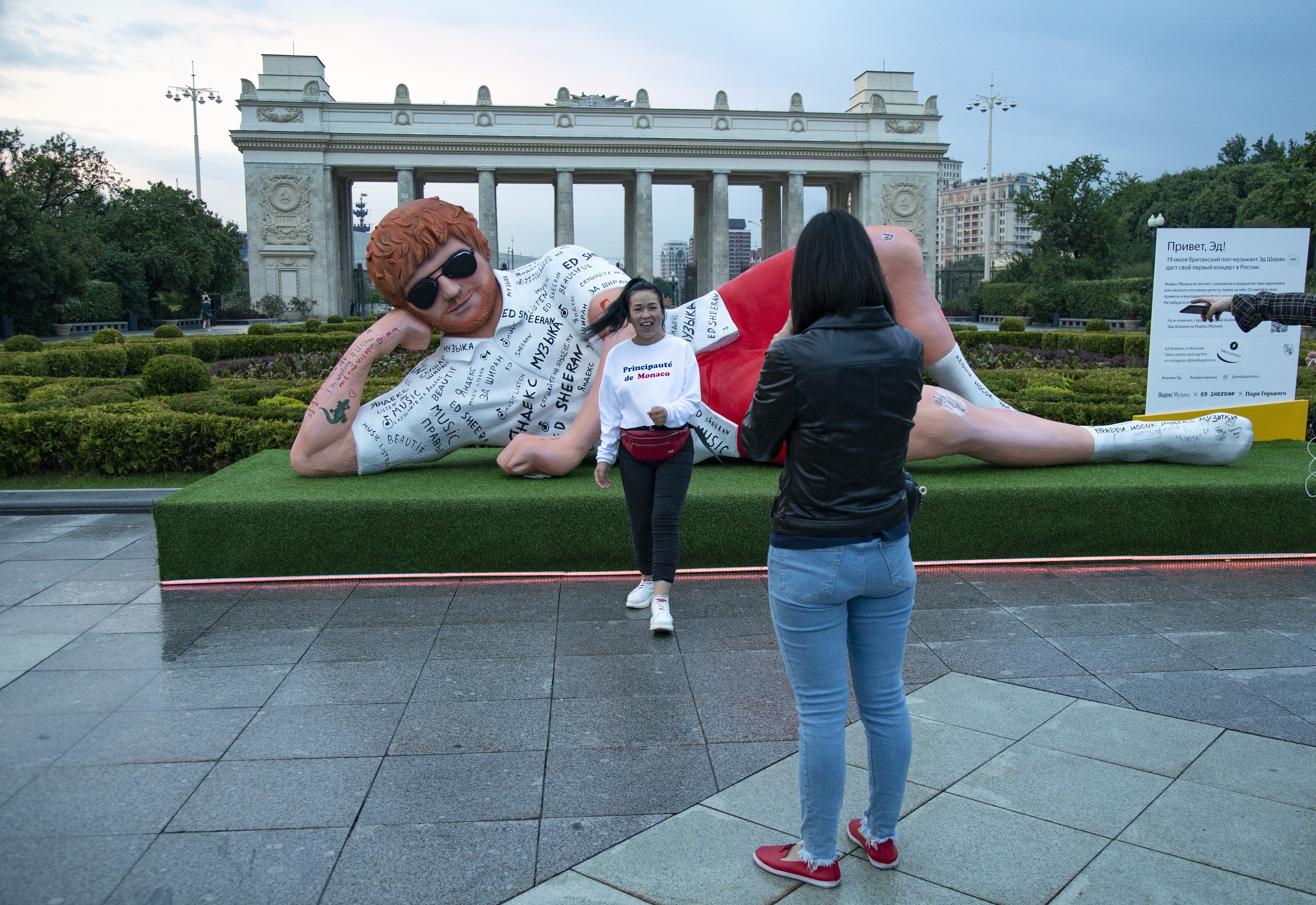 A woman poses for a photo in front of the statue 