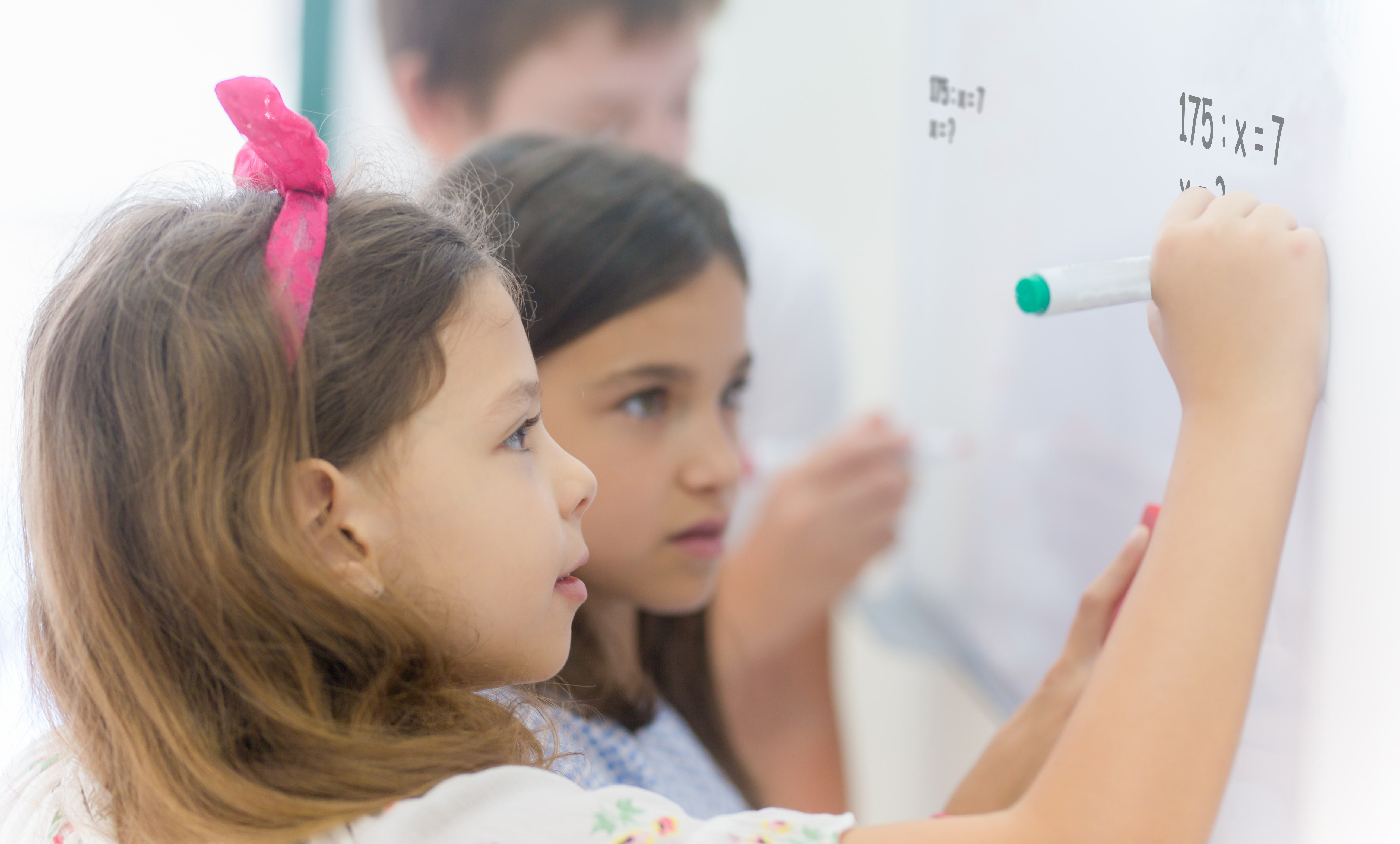 Children doing arithmetic on a whiteboard