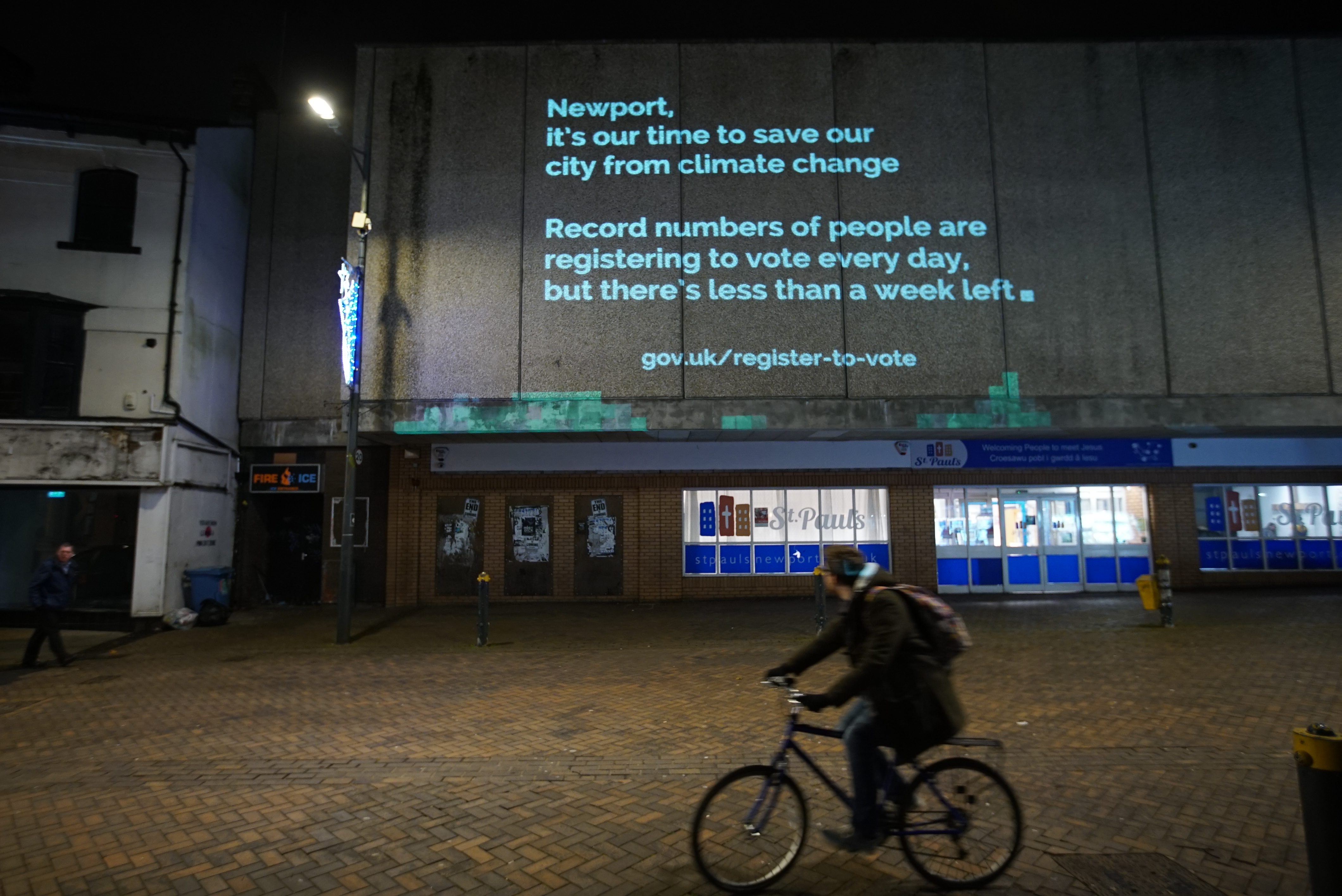 A message urging young people to register to vote projected onto a building