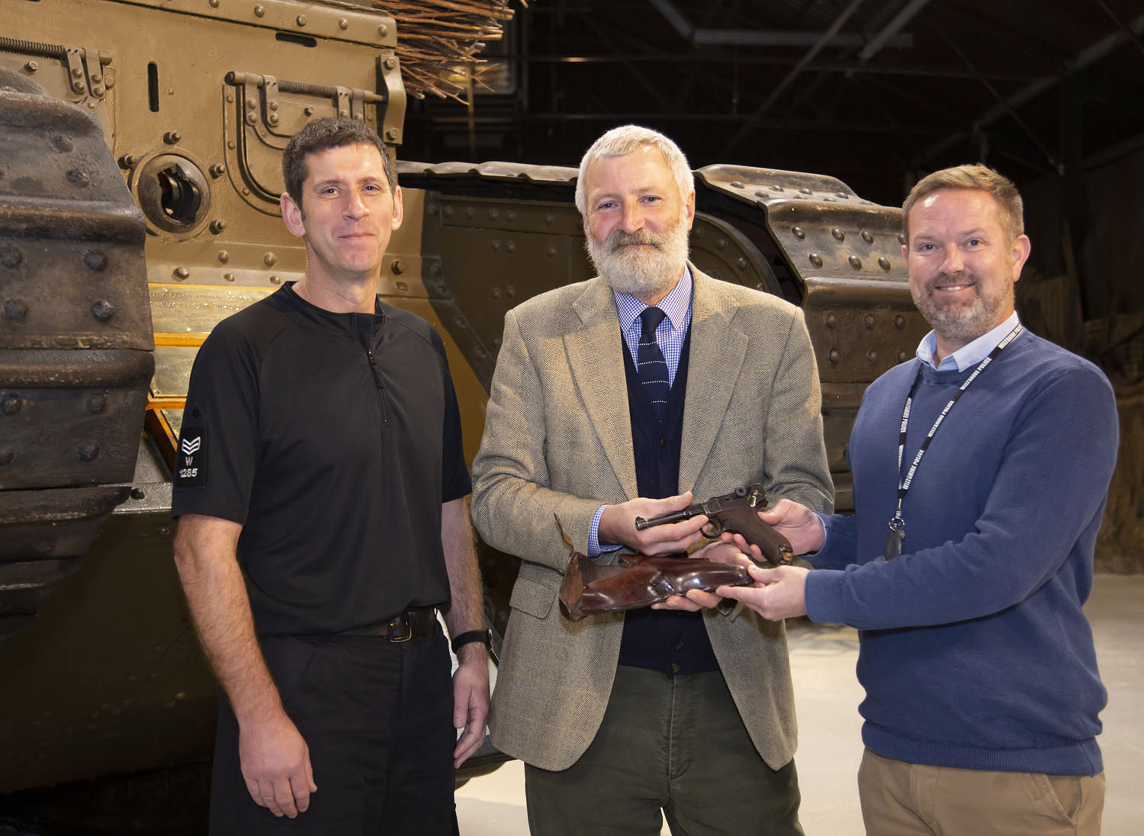 Tank Museum curator David Willey (centre) receives the Luger from (left) Wiltshire Police Sgt Bill Monk and force armourer Jamie Ross (The Tank Museum/PA)