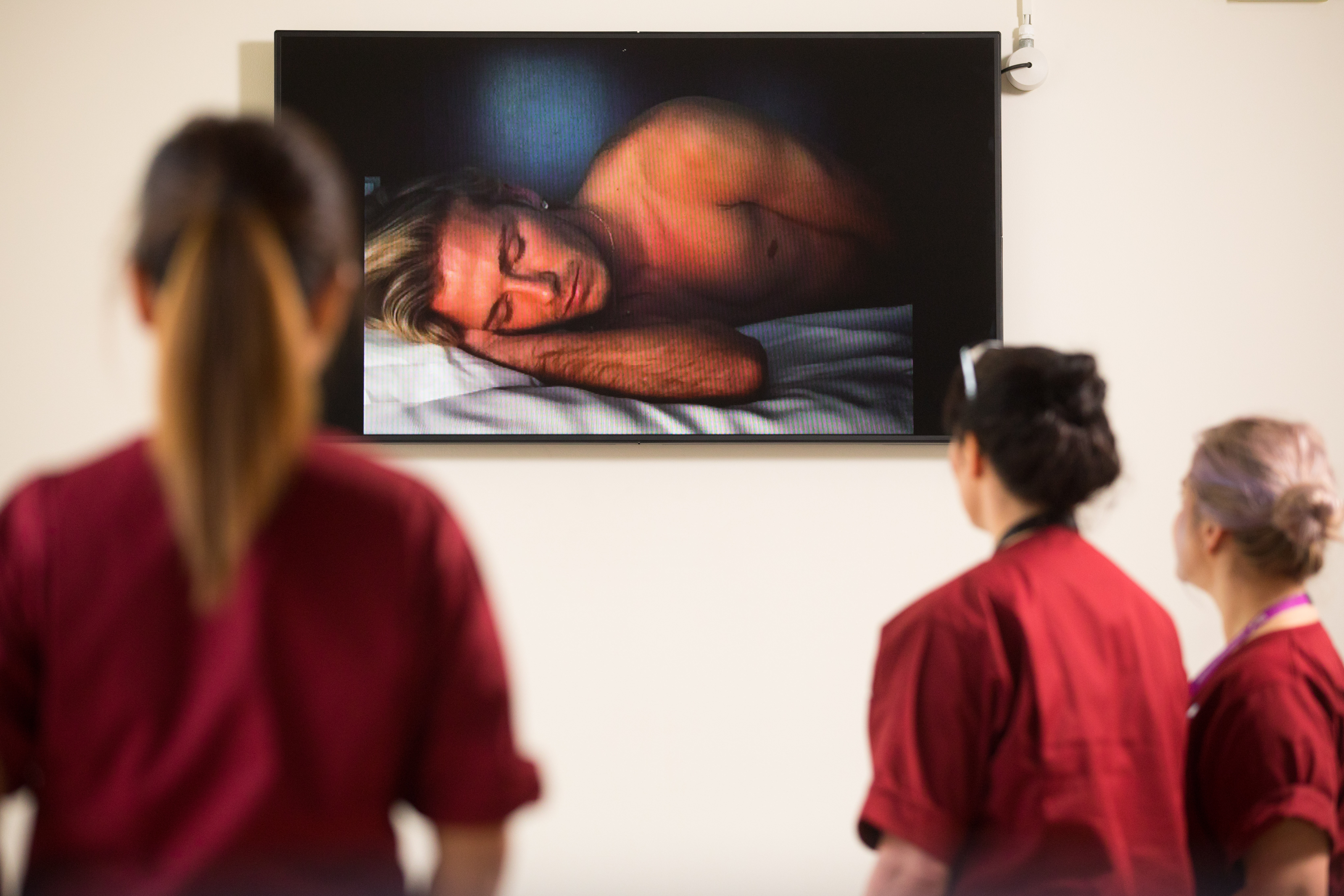 Hospital staff look at the portrait of David Beckham by Sam Taylor-Johnson 