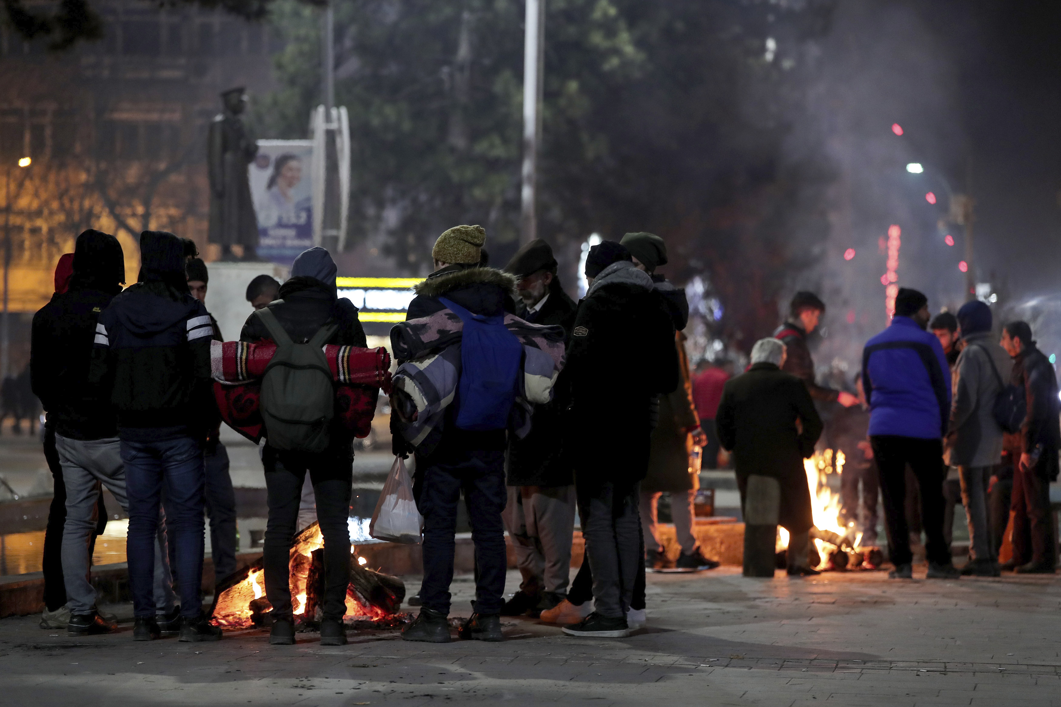 People gather around fires