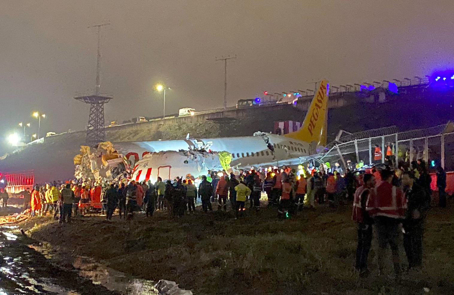 Rescue members and firefighters work after a plane skidded off the runway at Istanbul's Sabiha Gokcen Airport