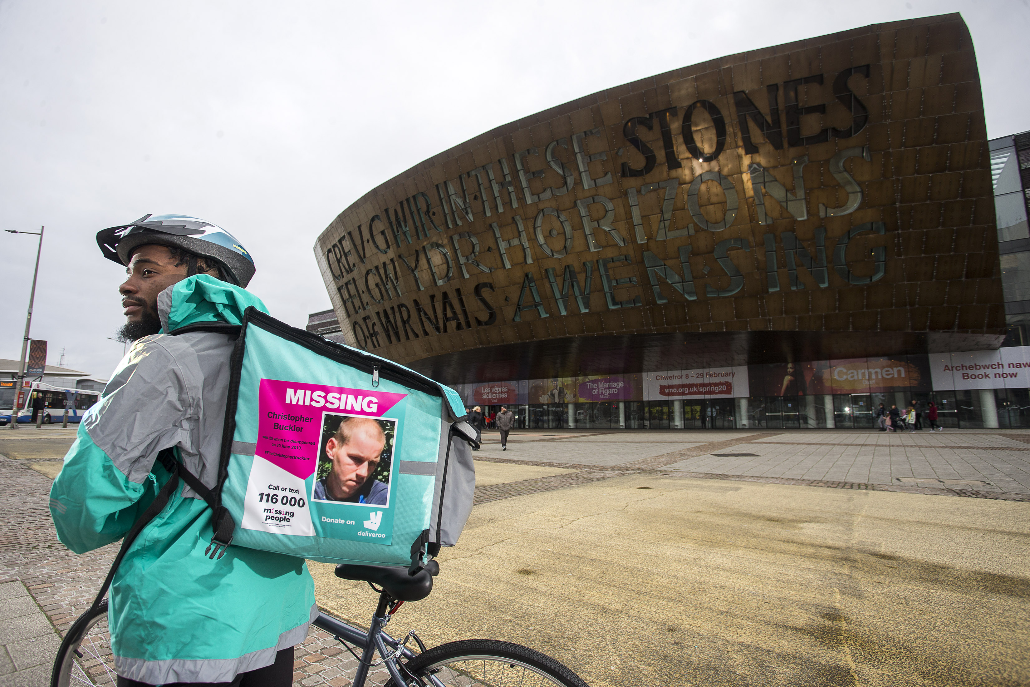 A Deliveroo driver with a missing person poster on their backpack