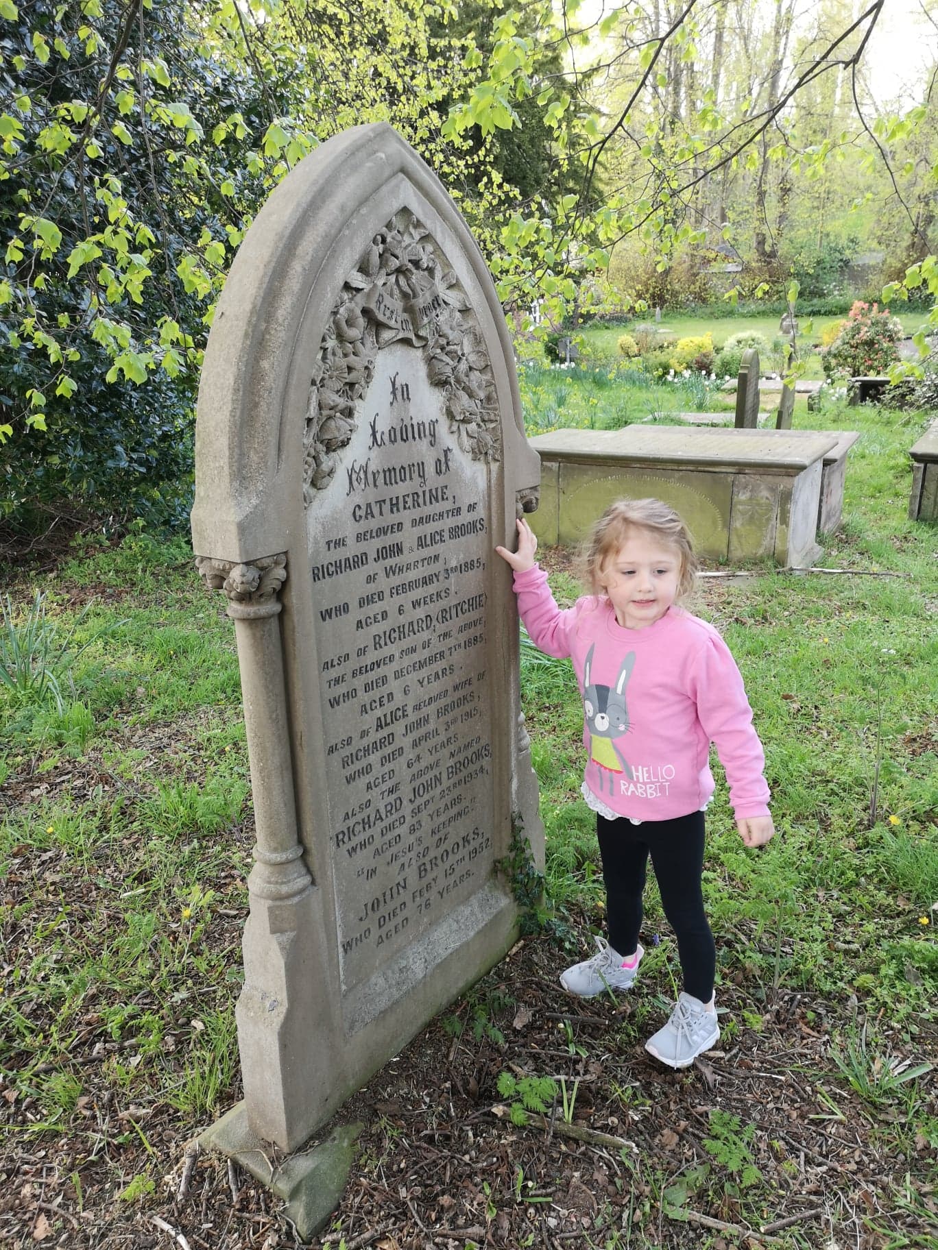 Lana stands with a cleaned up gravestone