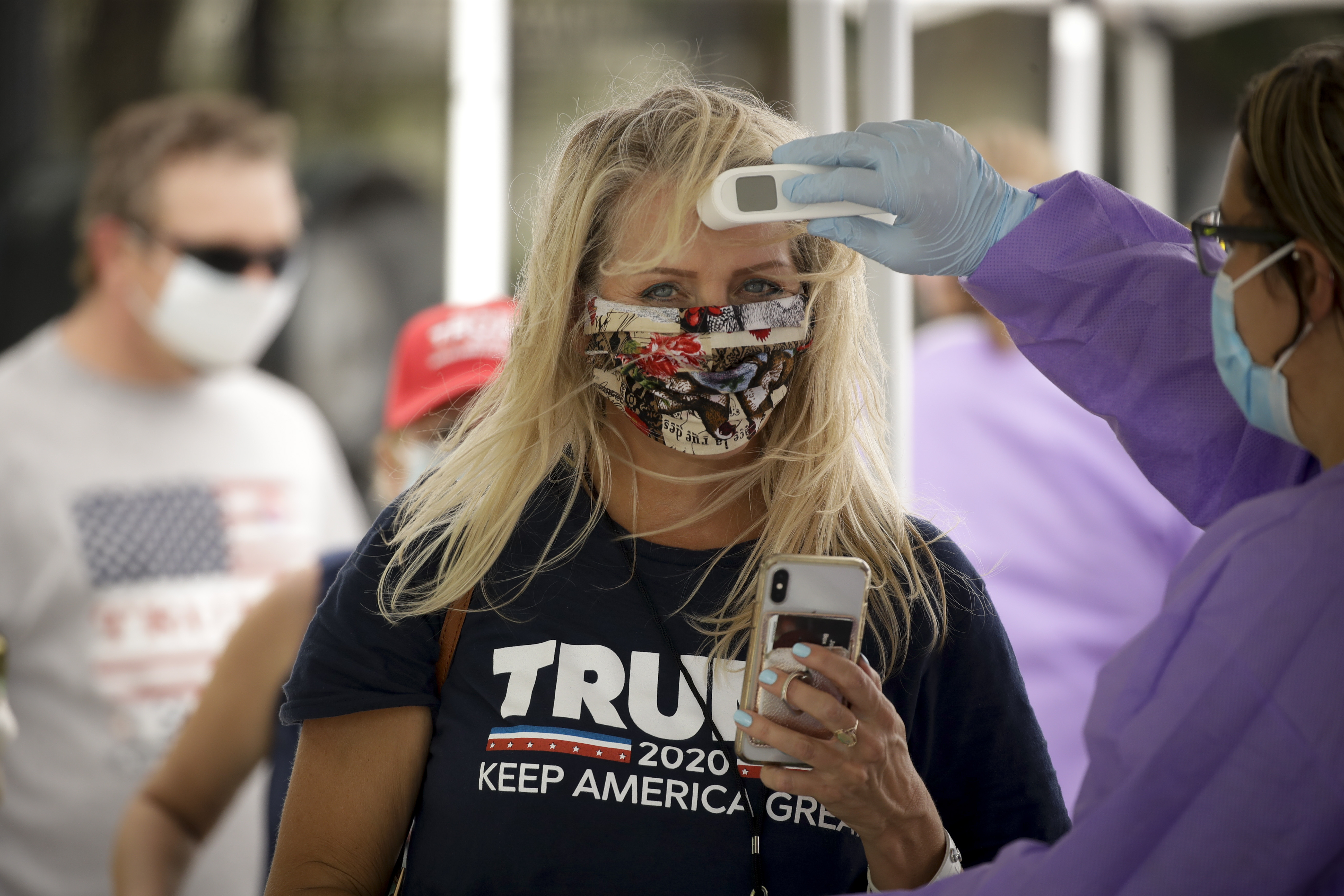 A Trump supporter gets her temperature checked