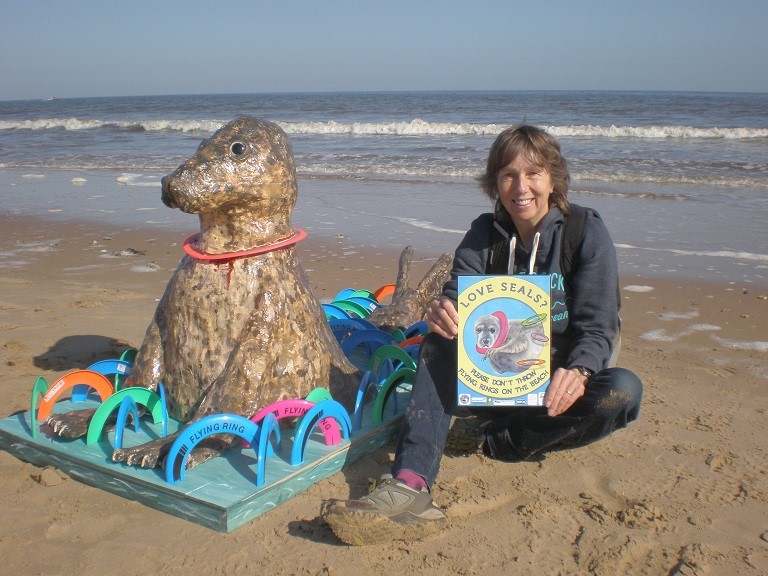 Campaign co-ordinator Jenny Hobson with the sculpture of a seal with a flying ring stuck round its neck. The model is being used to demonstrate the dangers of the toys and will tour beaches this summer. (Richard Hobson/ Friends of Horsey Seals/ PA)