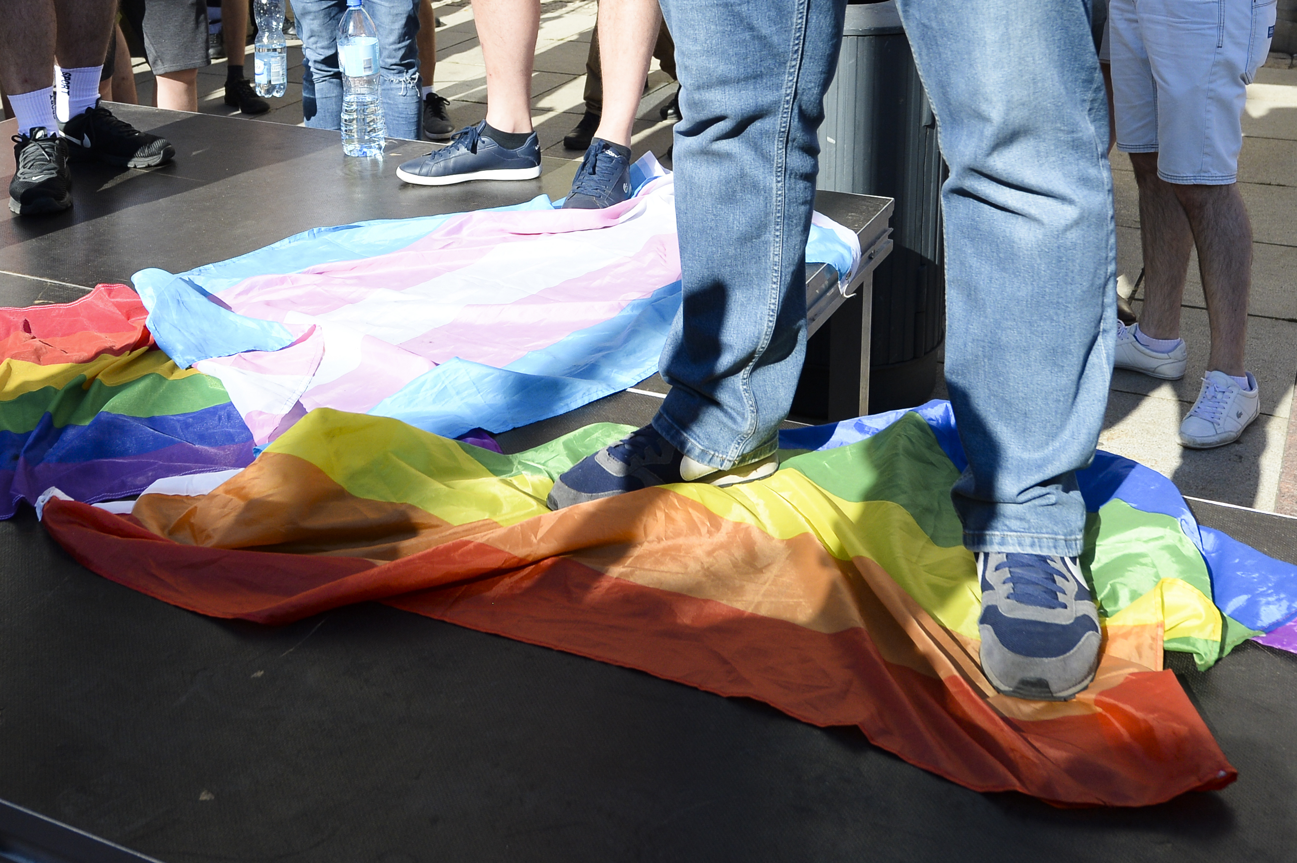 A man stands on a Rainbow Flag as he attends a demonstration of far-right activists against LGBT rights in Warsaw