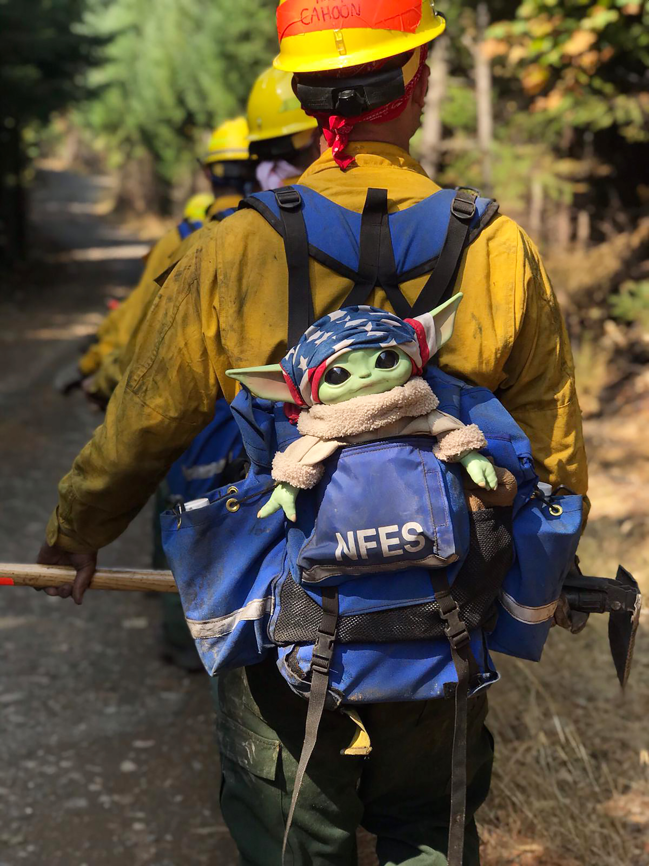 A Baby Yoda doll hitches a ride in the backpack of an Oregon Air National Guard firefighter