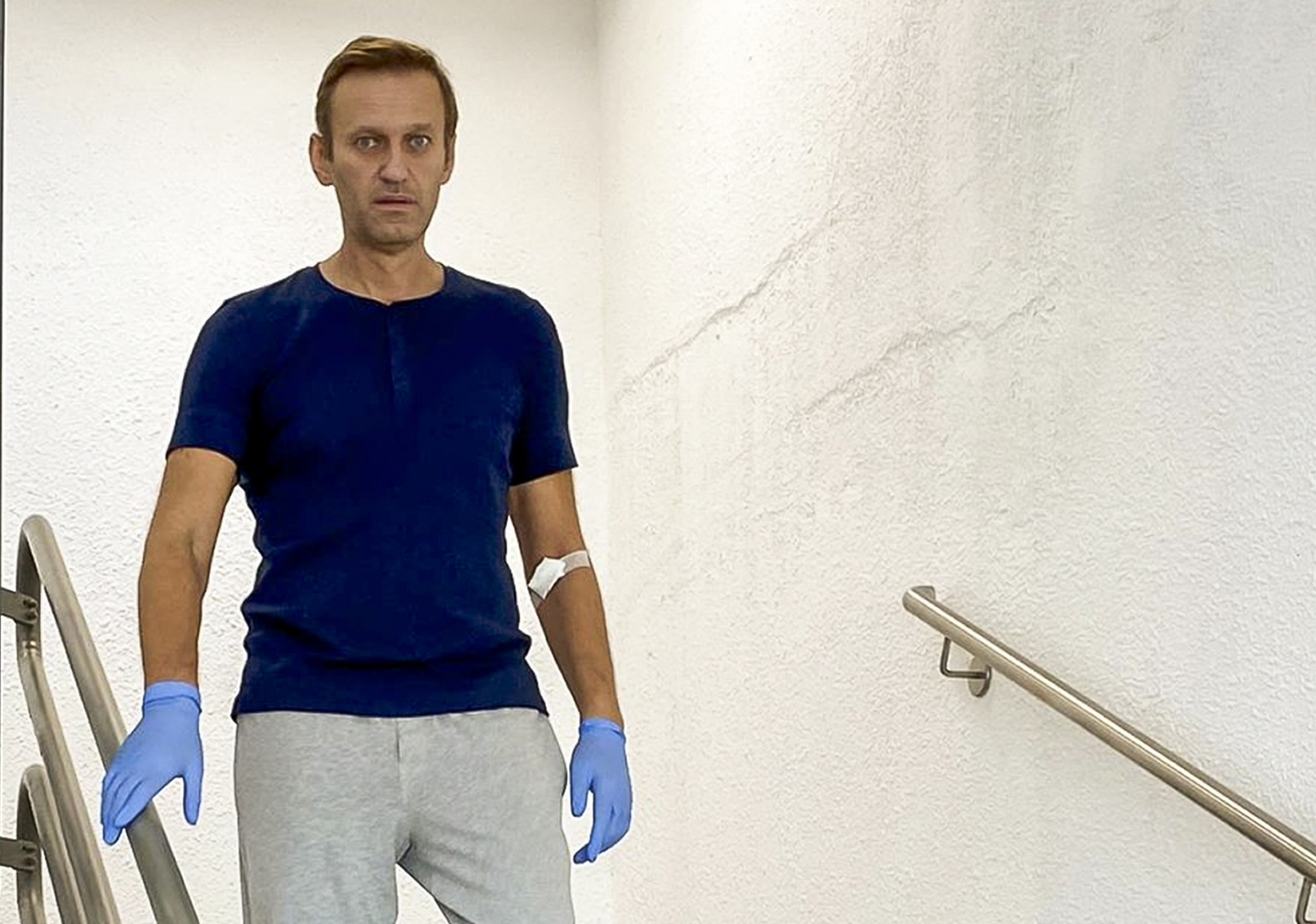 Russian opposition leader Alexei Navalny walks down stairs in a hospital in Berlin, Germany 