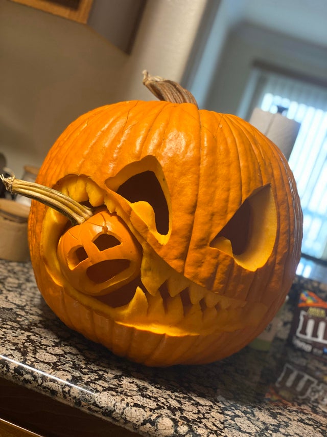 A pumpkin made to look like it is being eaten by another pumpkin