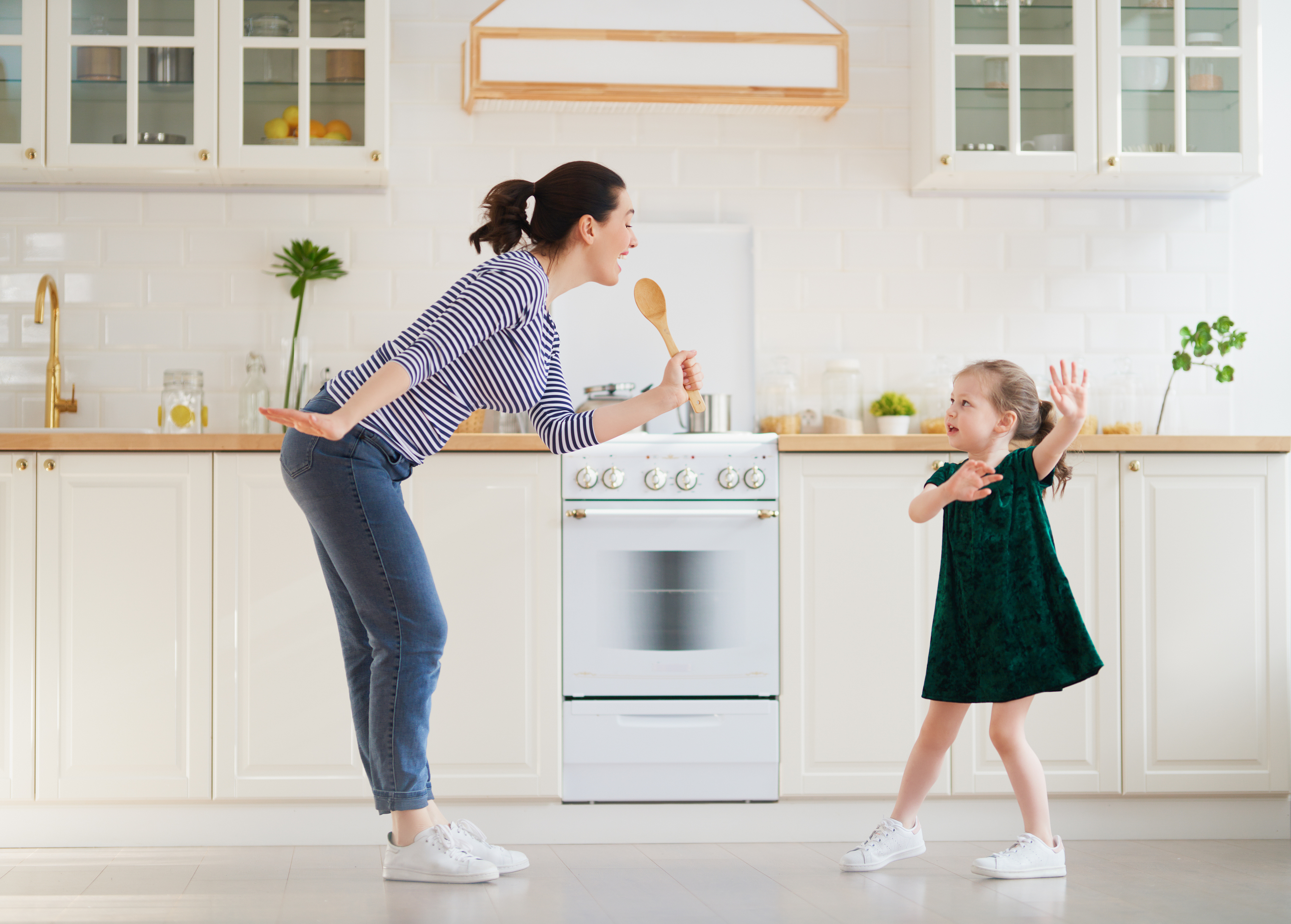 Mum and daughter dancing in a kitchen