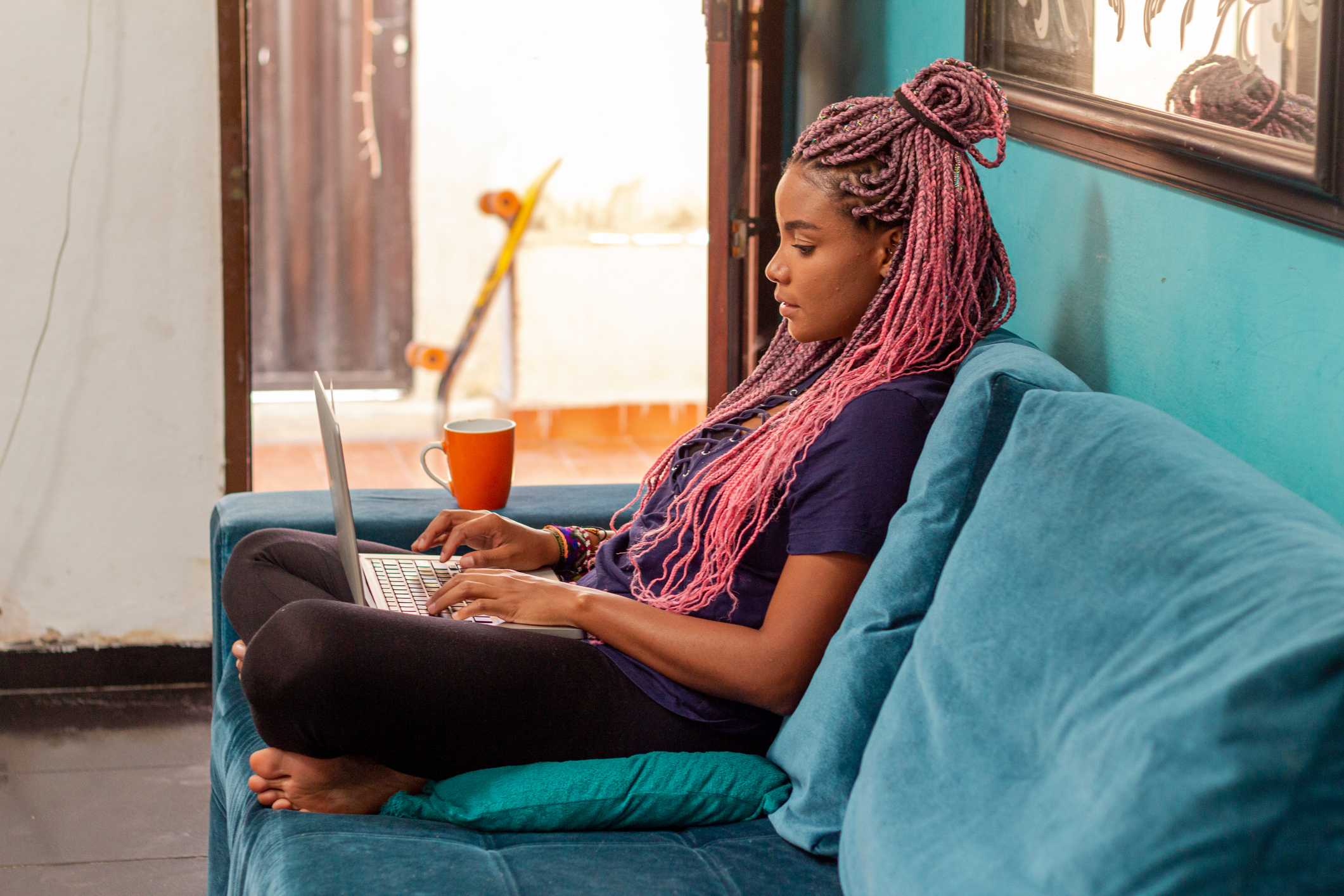 woman sitting on sofa with laptop