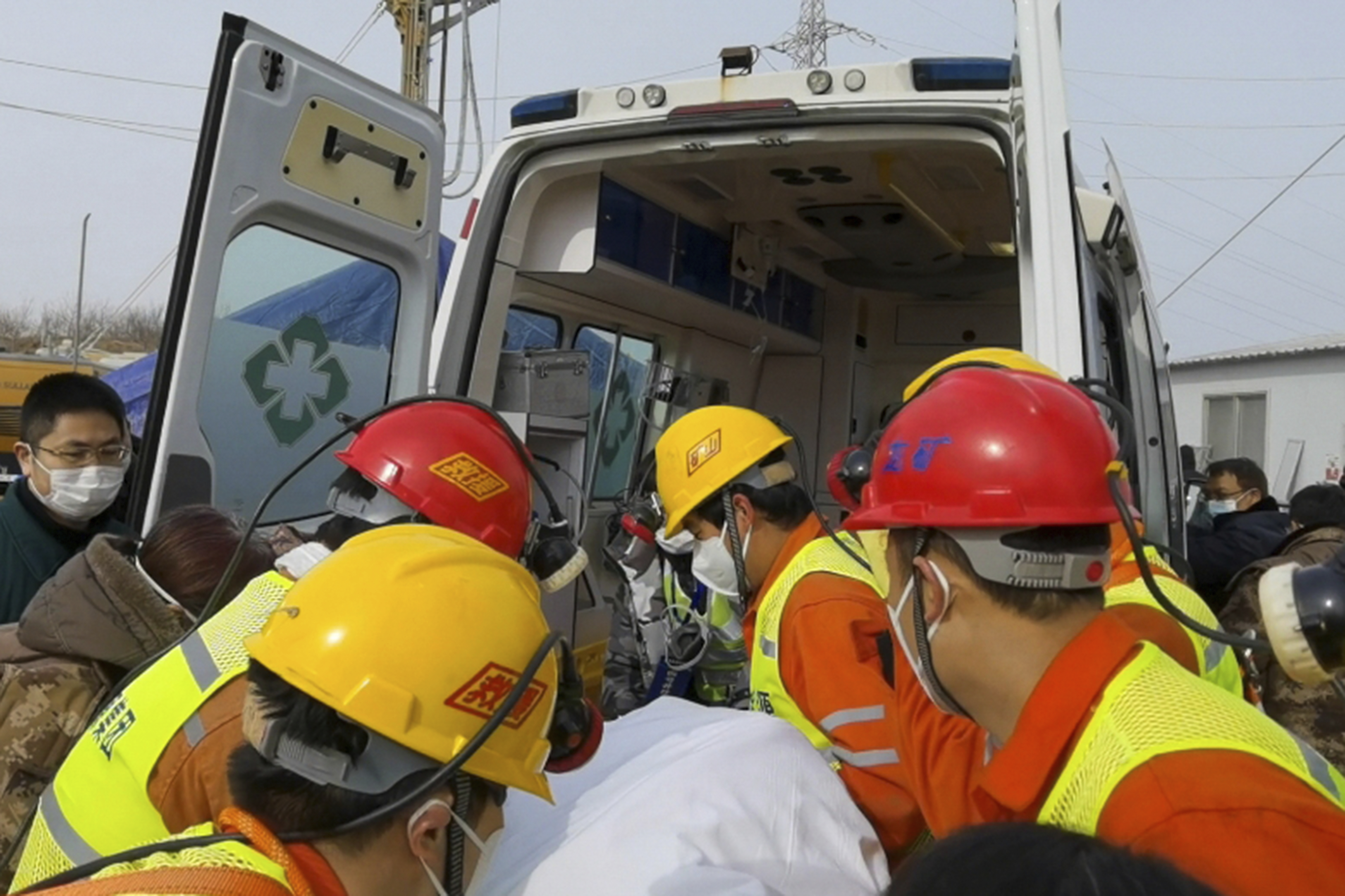 Rescuers carry a miner