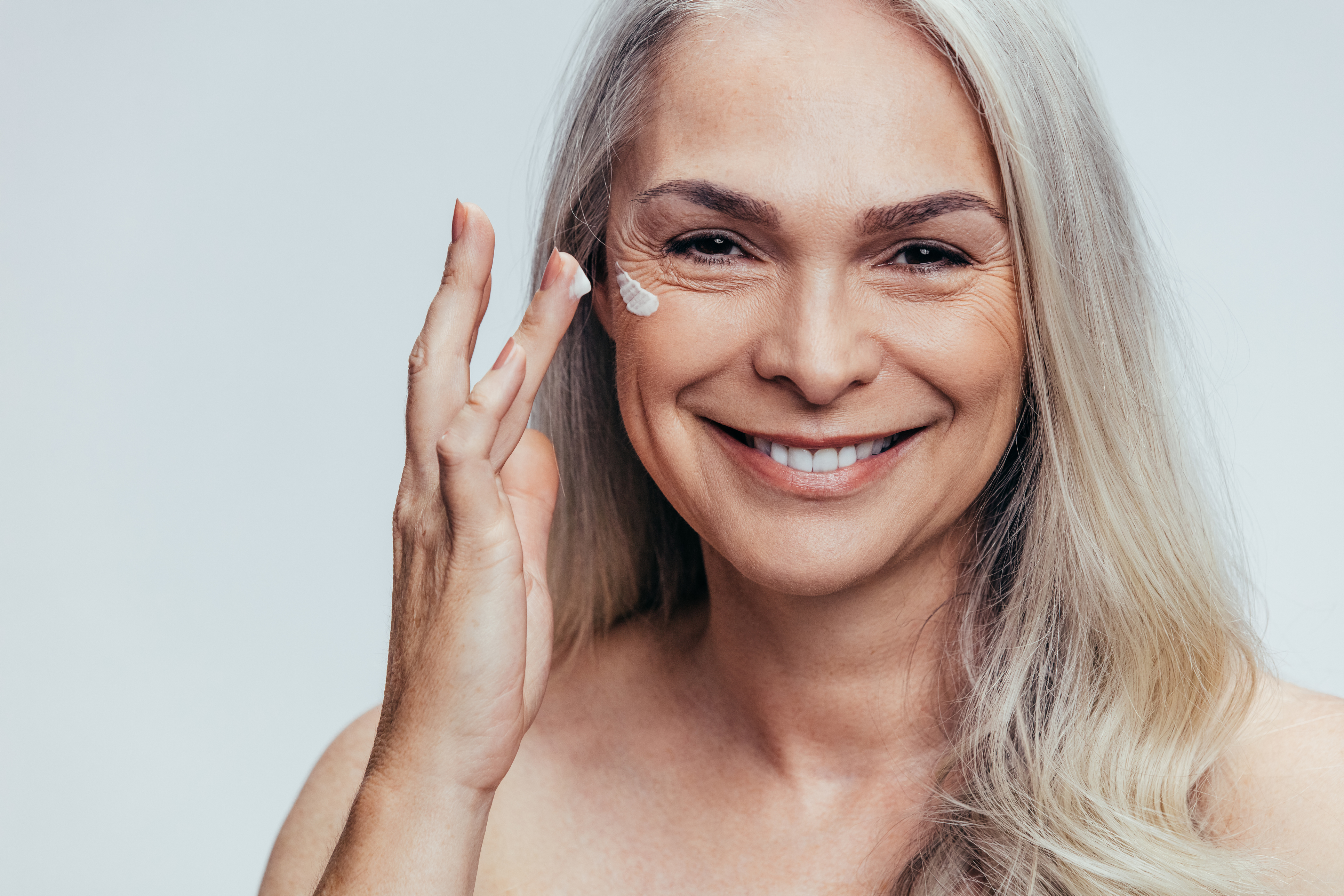 Woman applying rose product to skin