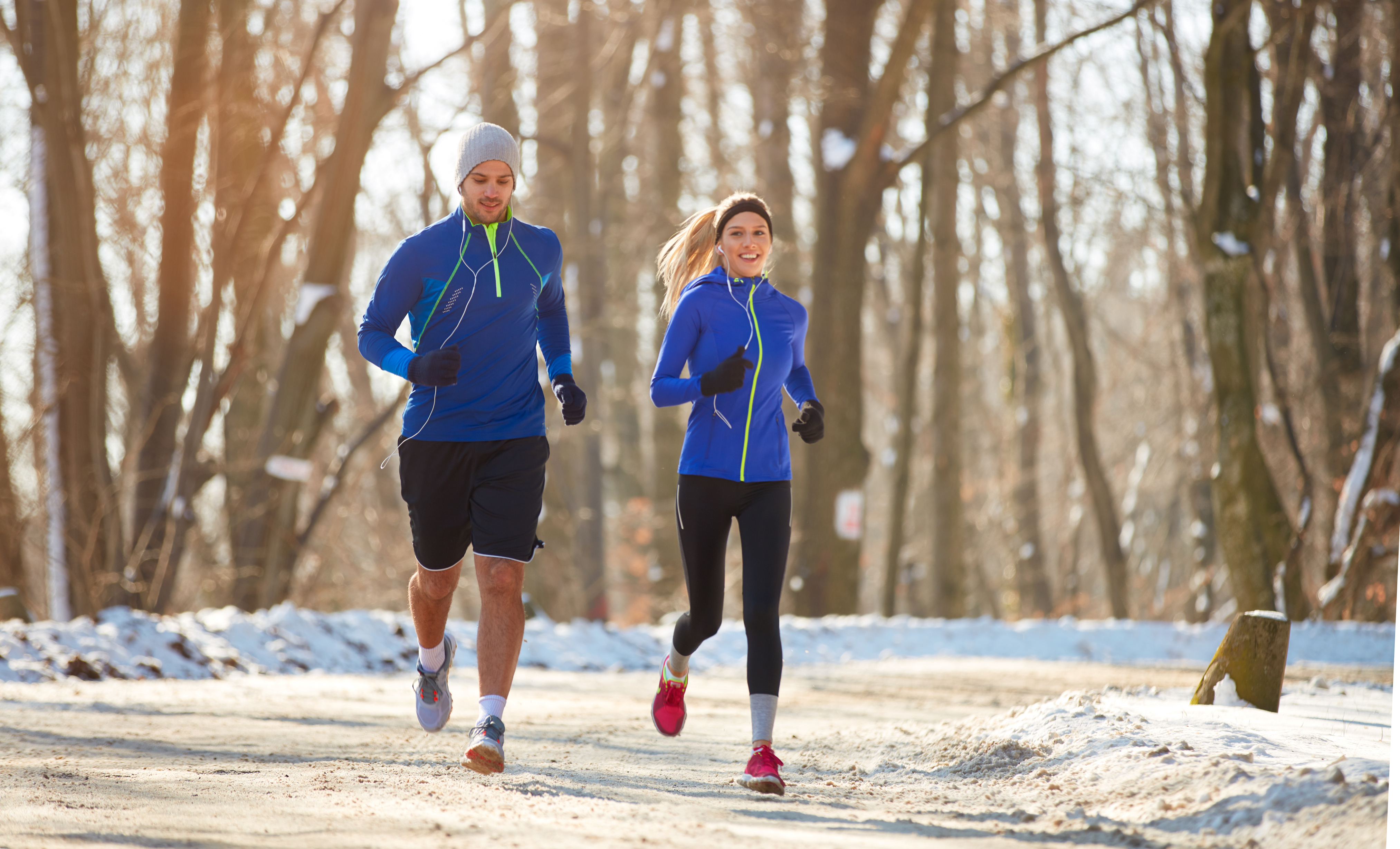 young couple running in the snow