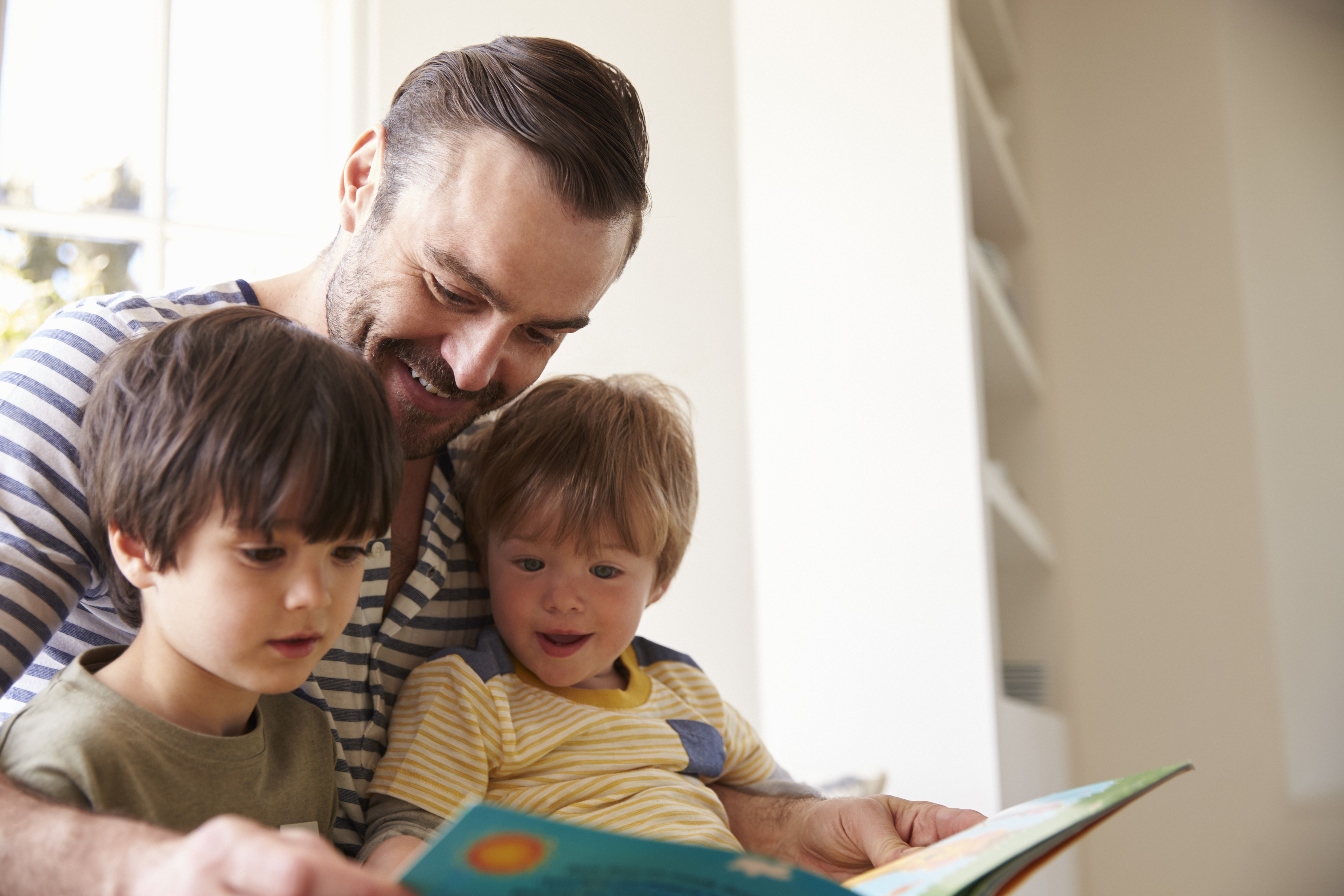 Father reading to two young sons