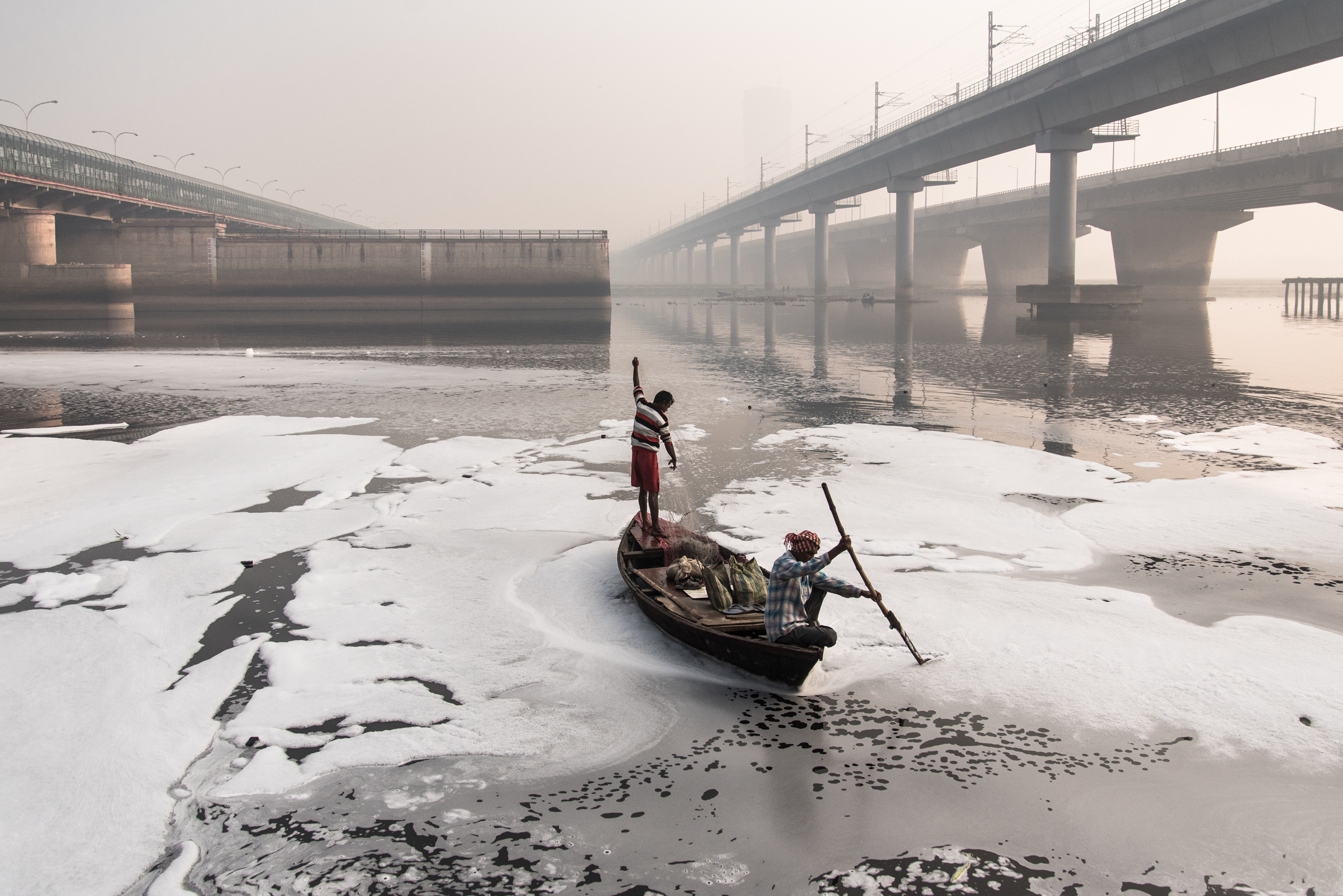 Two men on a boat in polluted New Delhi