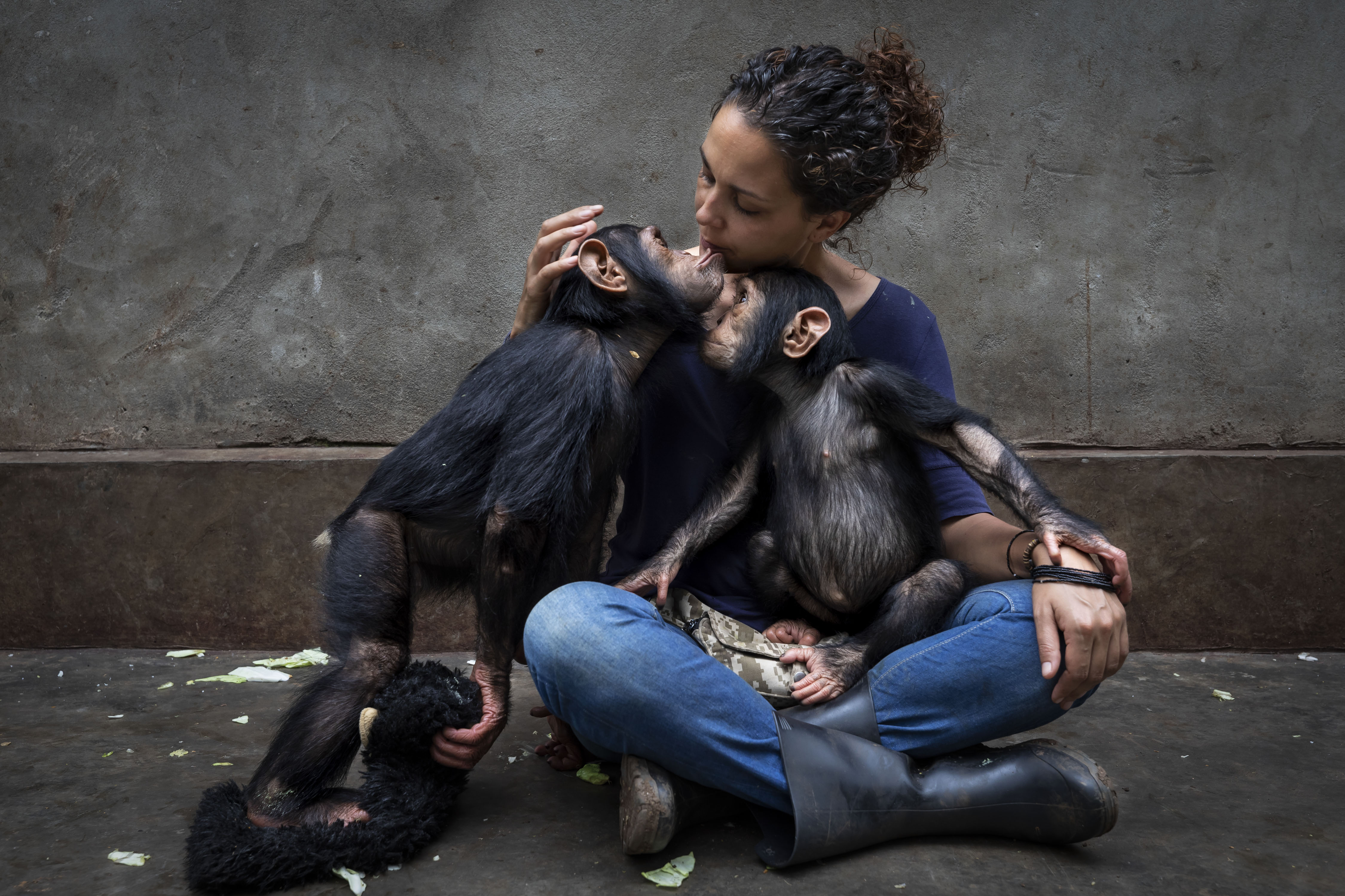 A woman holding two chimpanzees