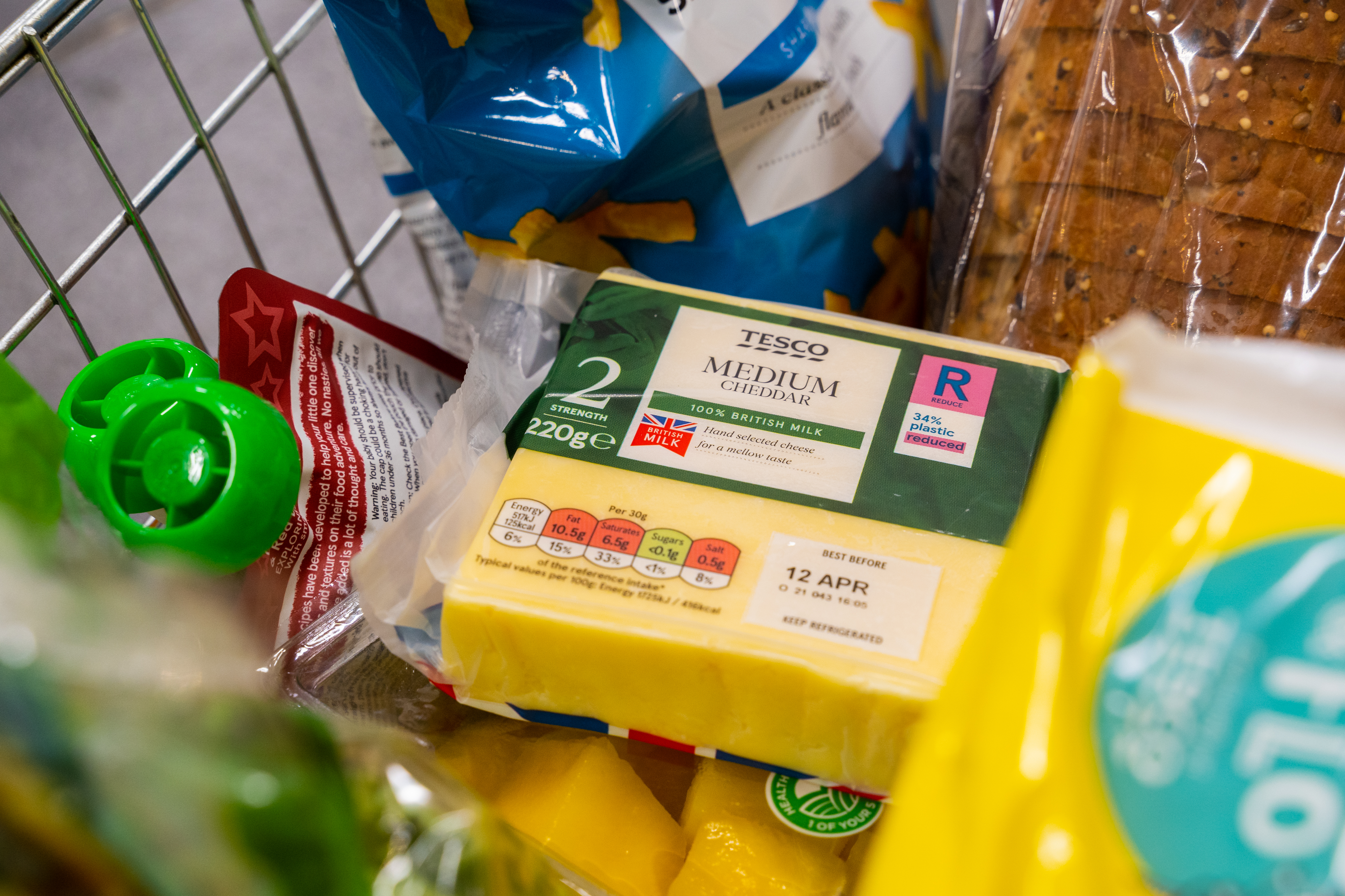 Tesco cheese in a shopping basket with a label showing packaging has been made from recycled plastic