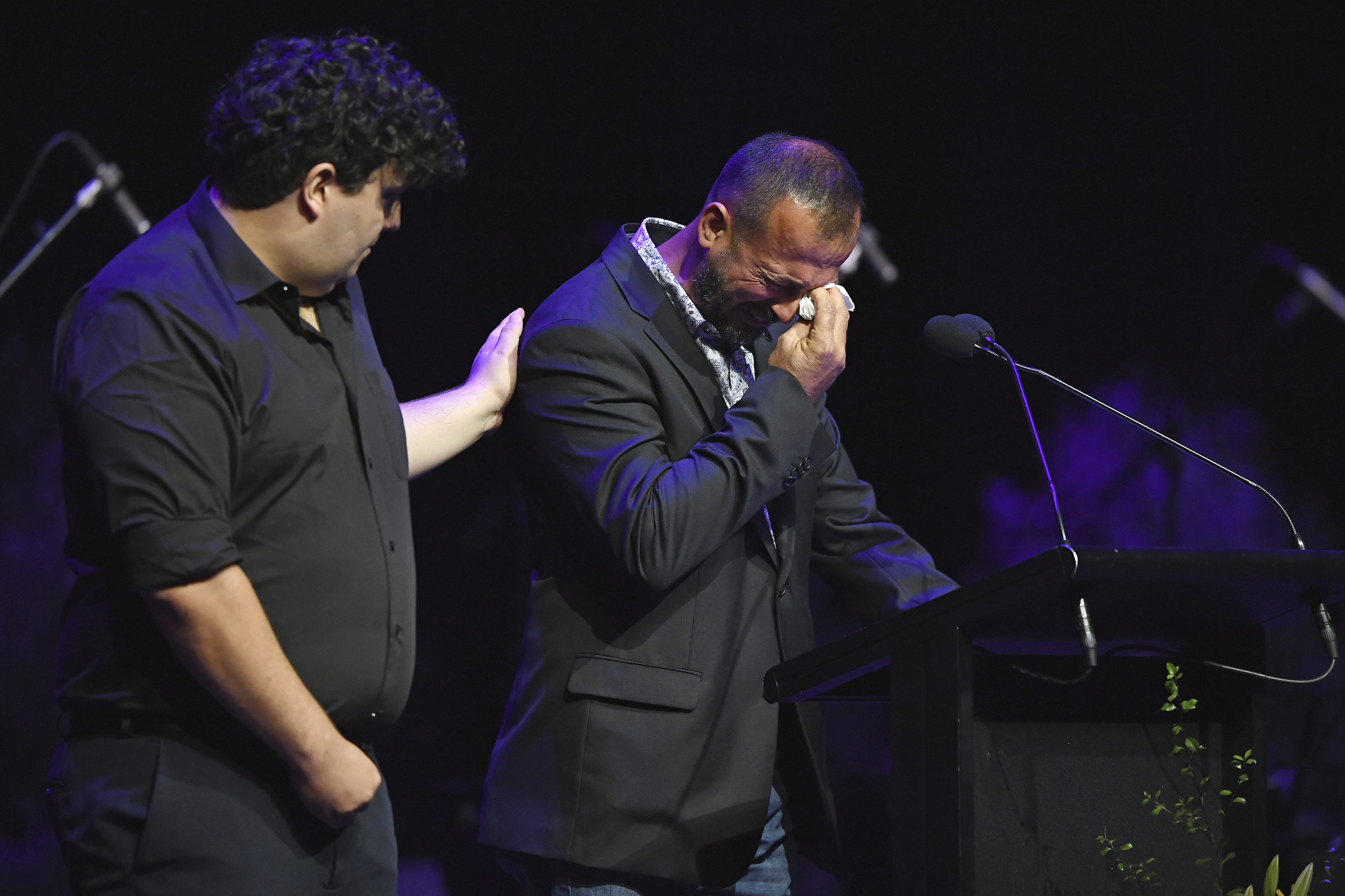 Temel Atacocugu, right, who survived being shot nine times during the attack on the Al Noor mosque, cries as he speaks at a remembrance service 