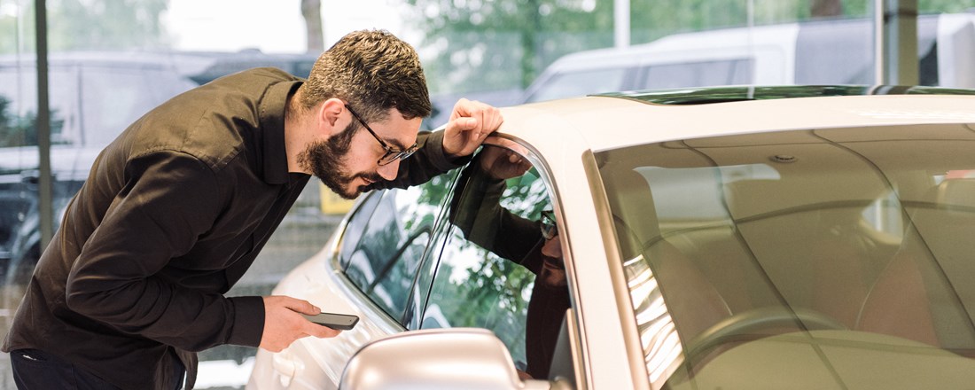 Man inspects car at a dealer