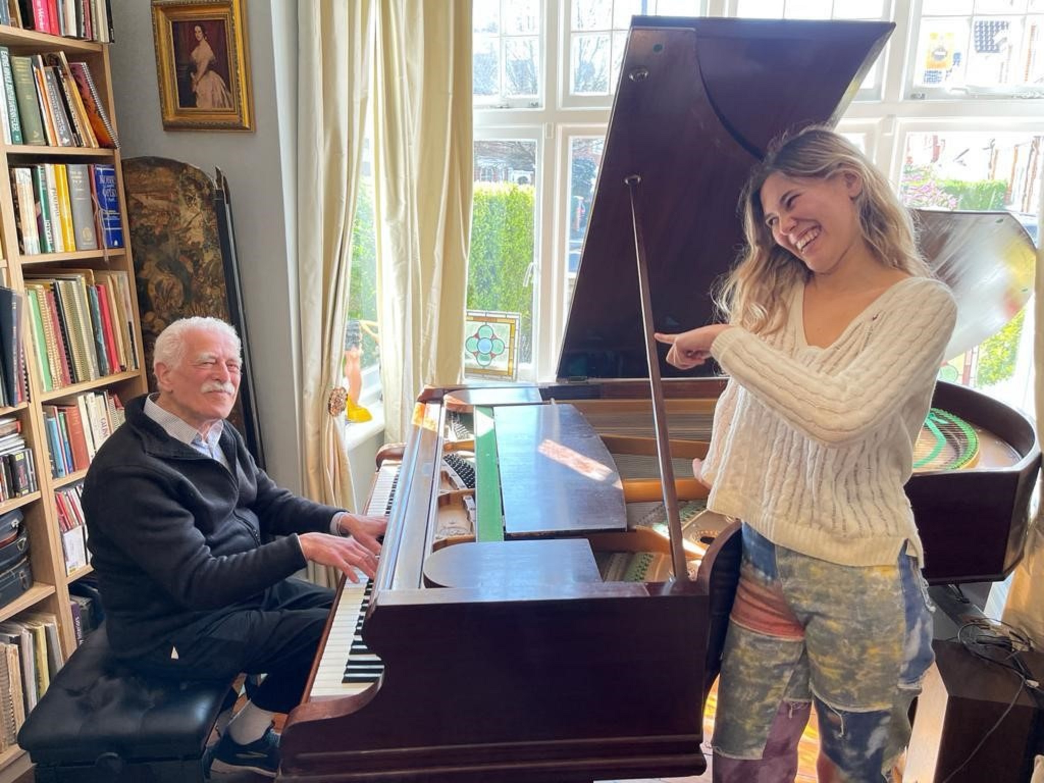 Alan Melinek playing the piano with his granddaughter Bella
