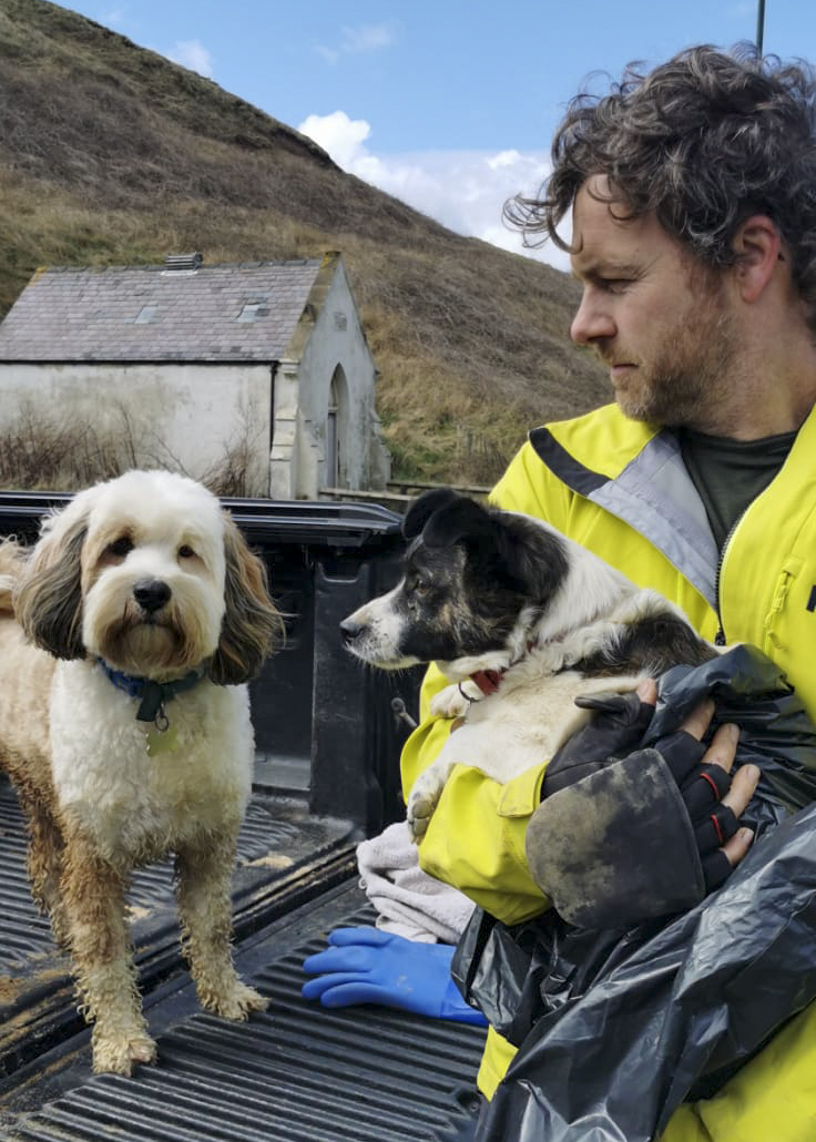 Ed Thomas and his dog Olly, with the rescued Jack Russell in his arms