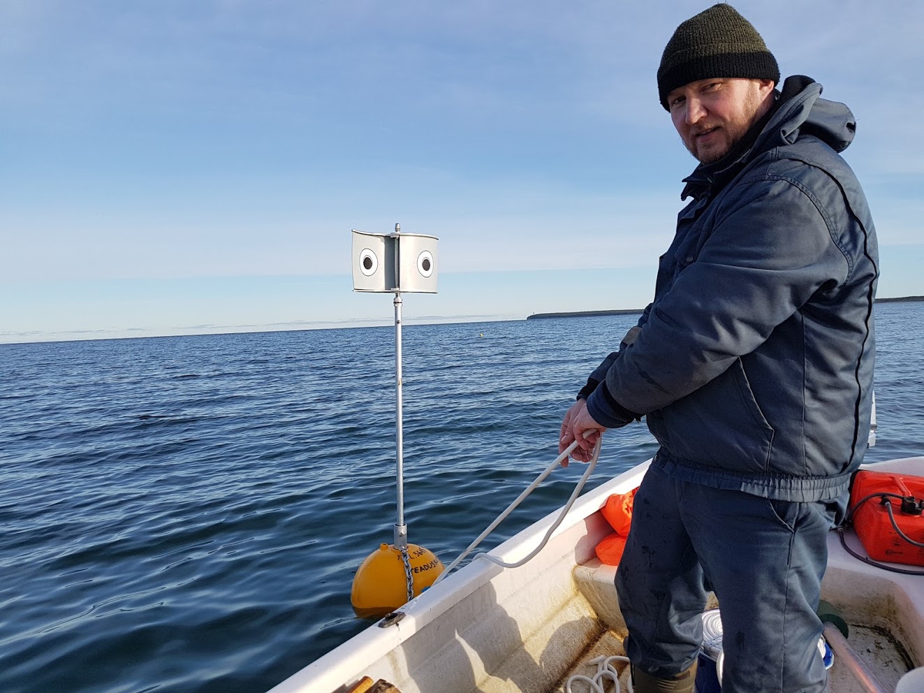 Field worker Rein Nellis on his boat deploying one of the deterrent within the observation plot (Andres Kalamees/PA)