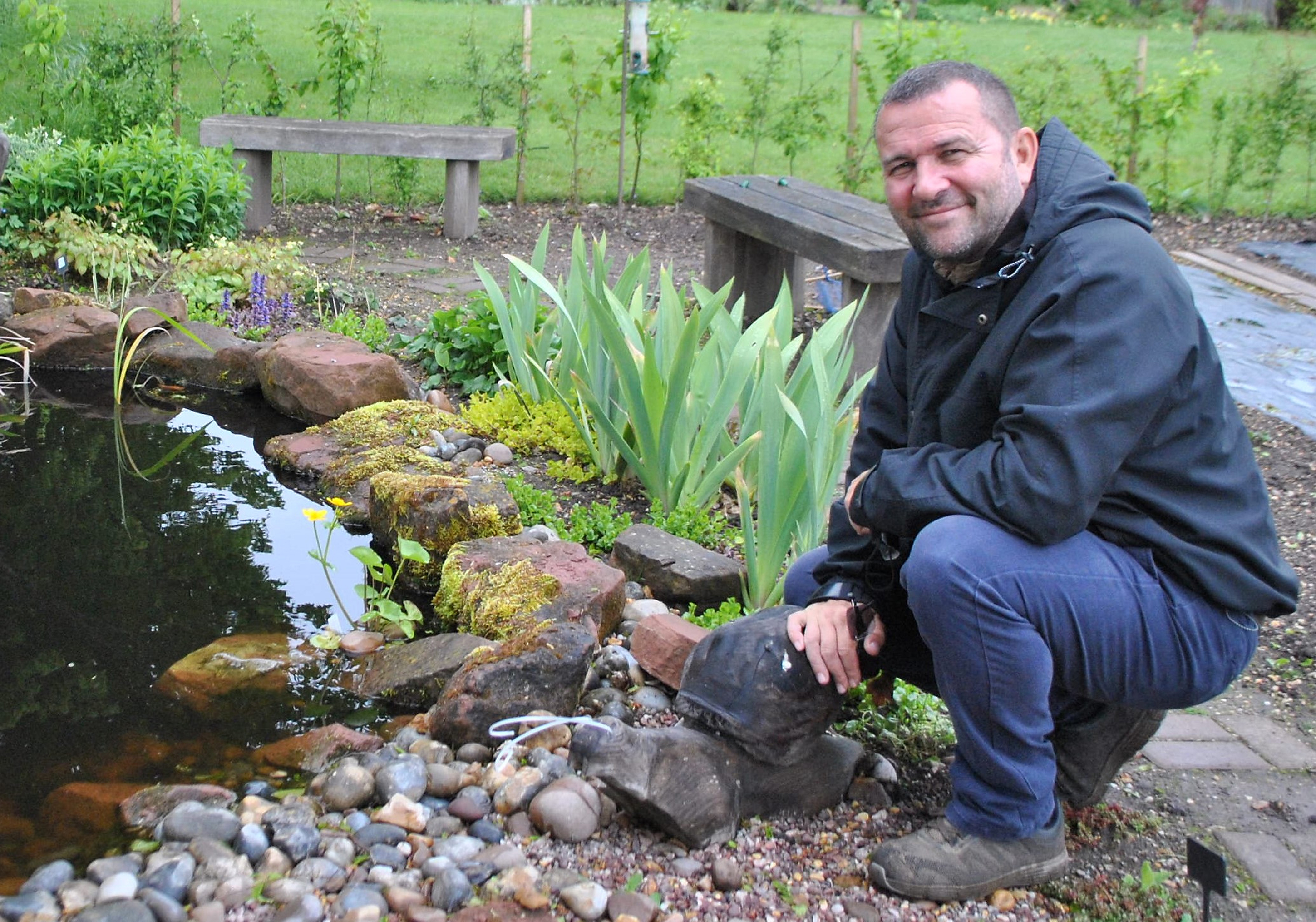 Chris Collins, head of horticulture at Garden Organic, next to a pond (Garden Organic/PA)