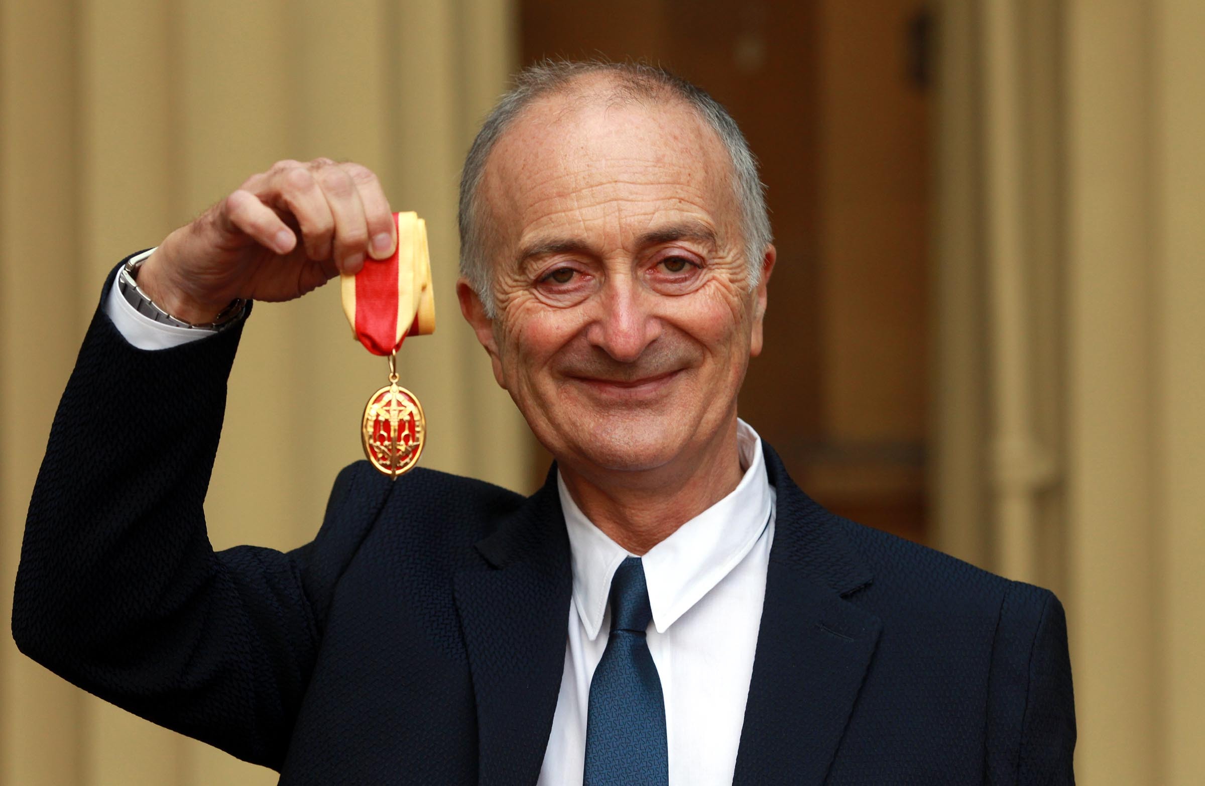 Sir Tony Robinson holds his medal after being knighted in 2013