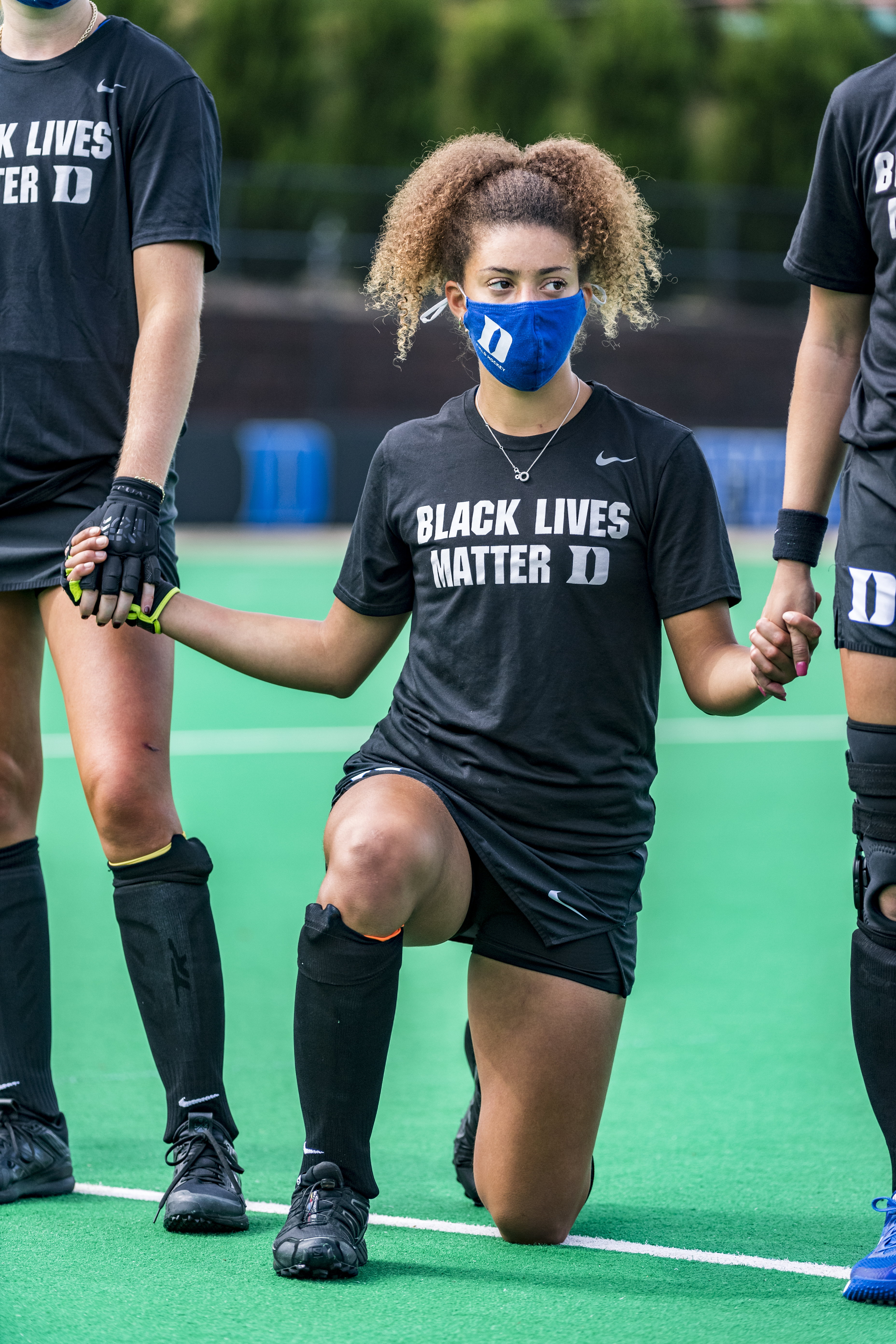 Darcy Bourne takes the knee while wearing a Black Lives Matter T-shirt
