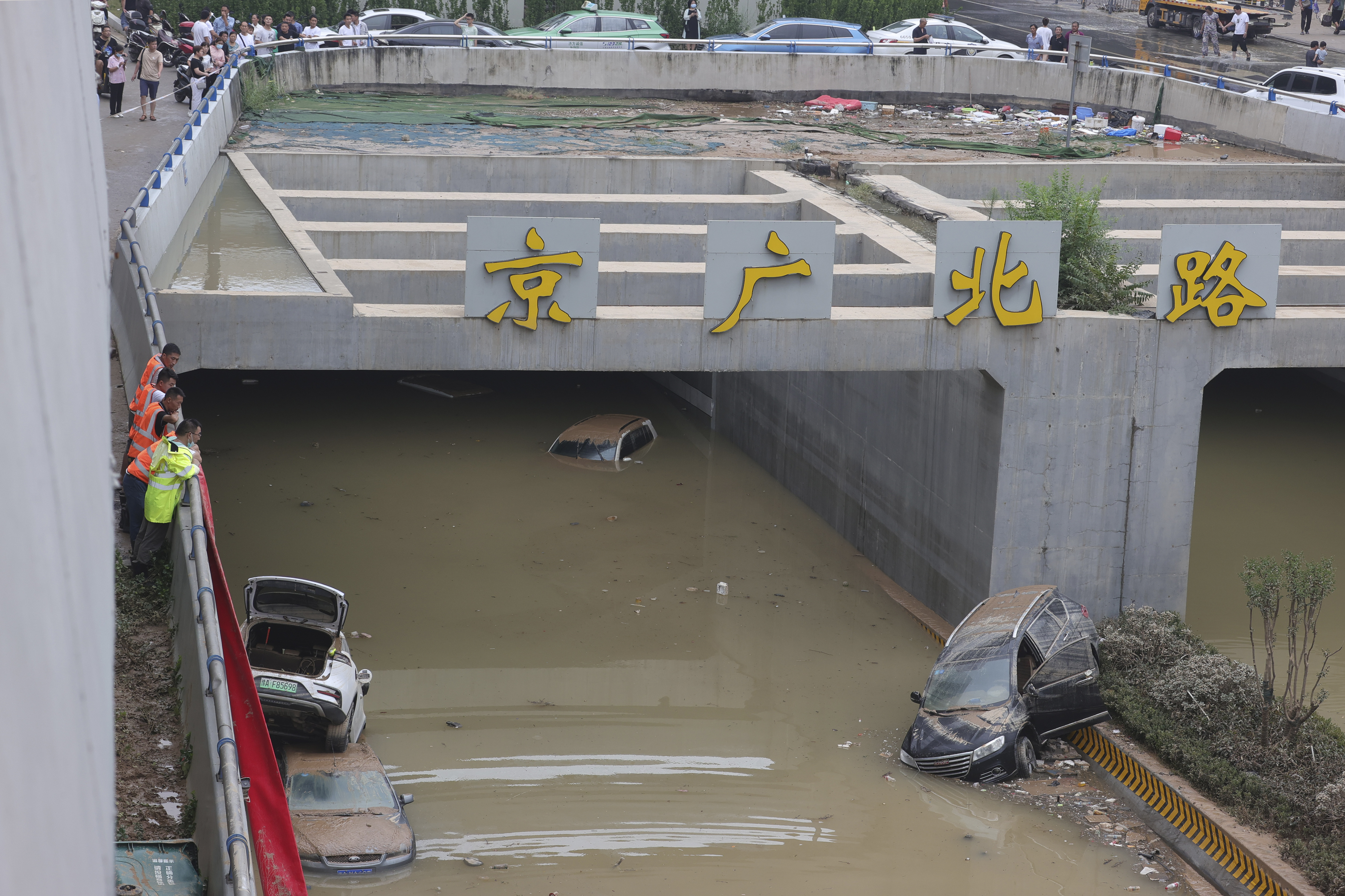 Rescuers watch as water is pumped from a road tunnel