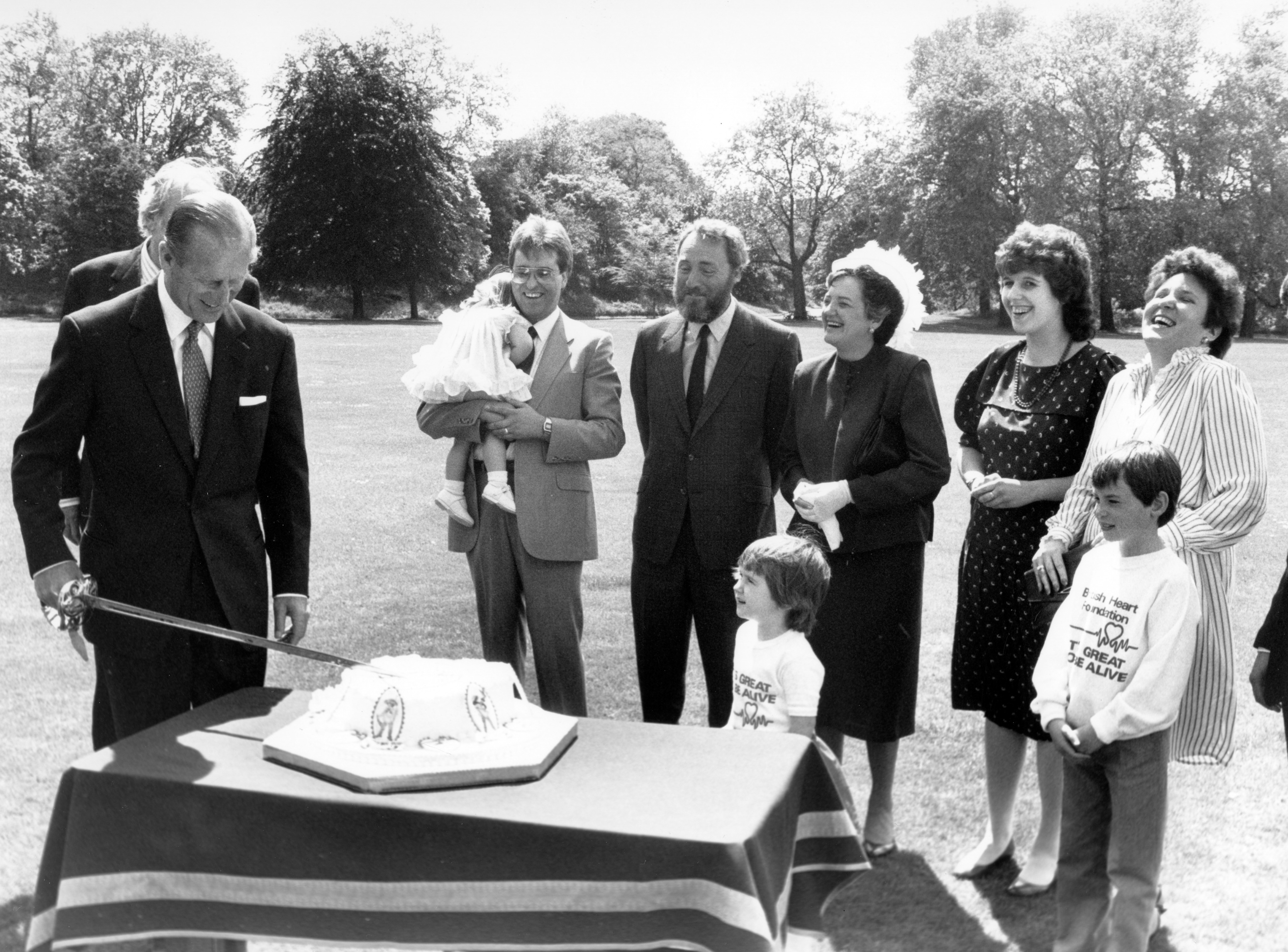 Patron of the British Heart Foundation, the Duke of Edinburgh in the grounds of Buckingham Palace cutting a heart-shaped cake to give a royal send-off to Heart Week '85 (PA/PA Archive) 