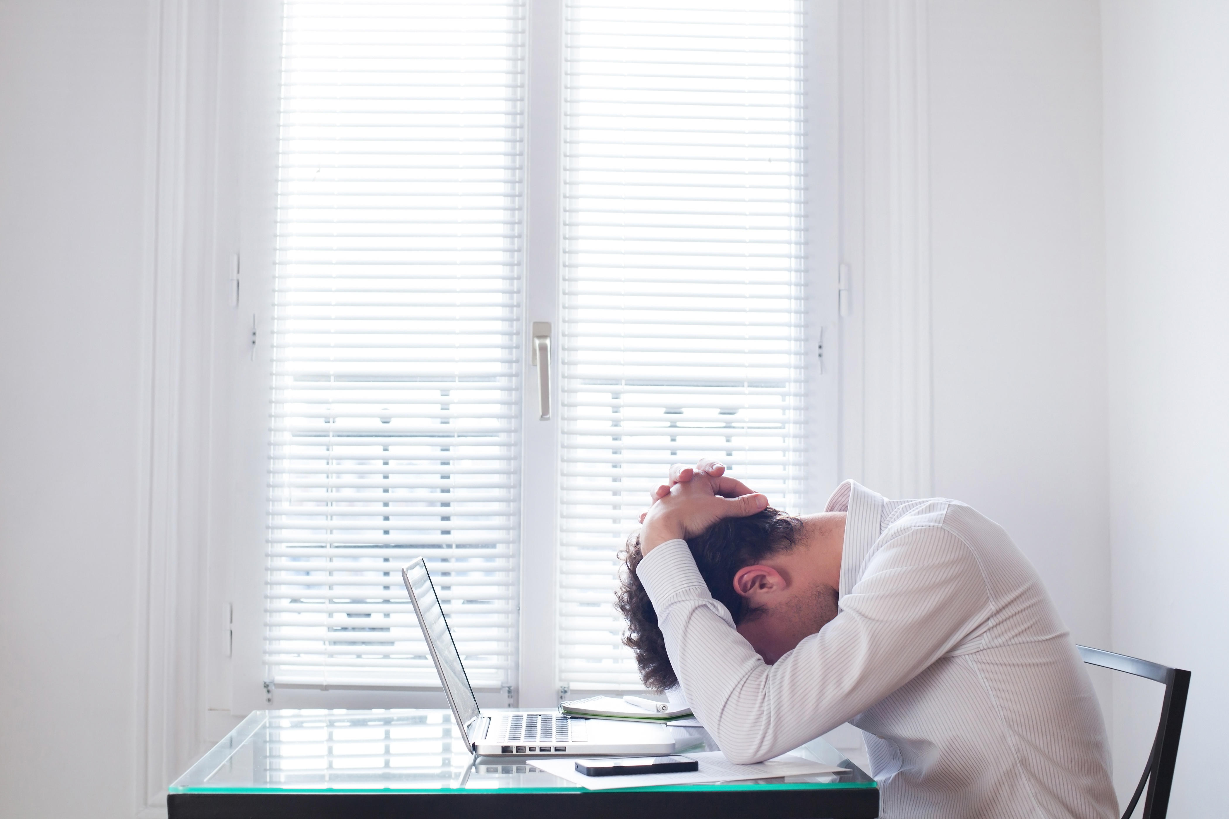 Stressed man at work (Alamy/PA)