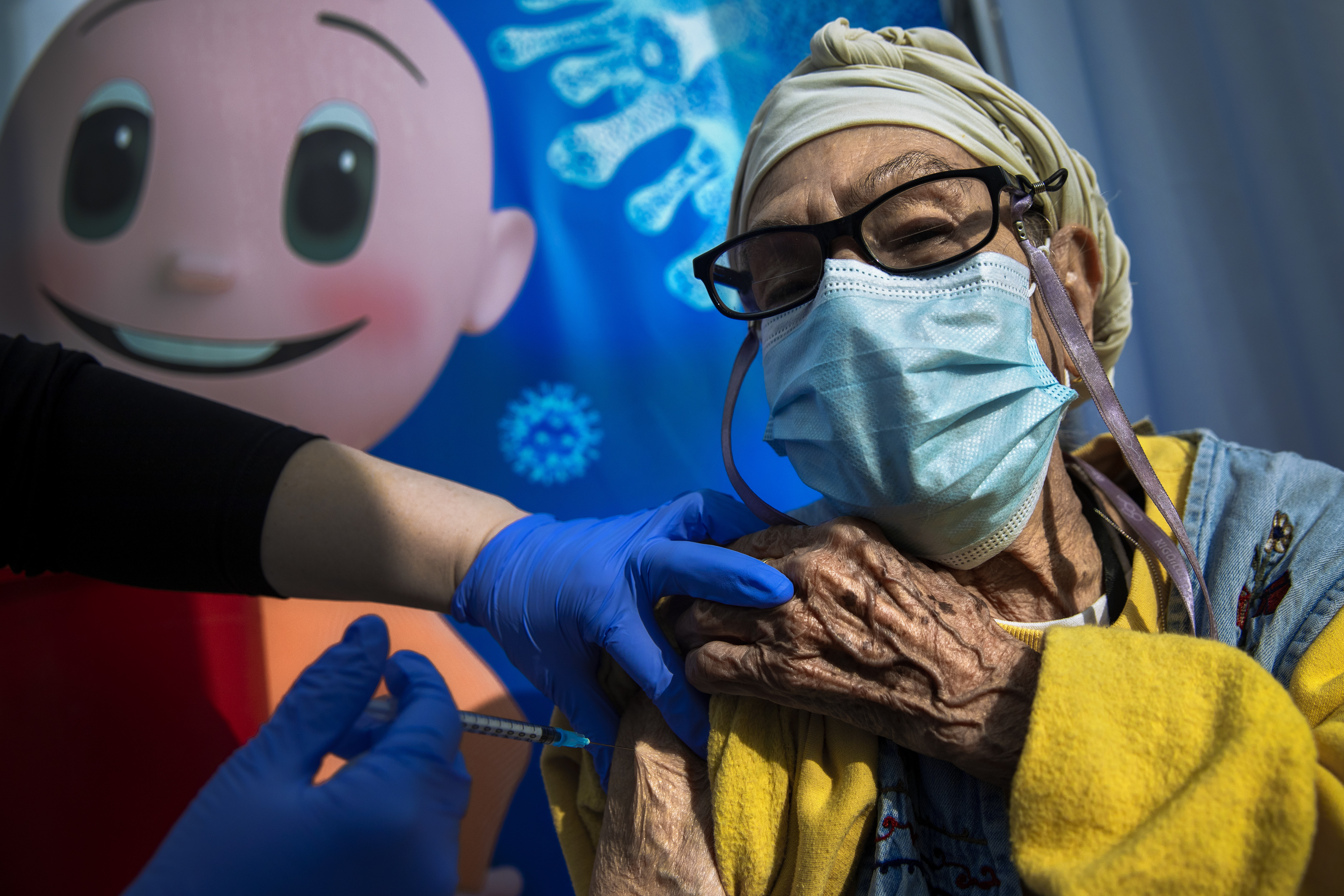 A woman receives a coronavirus vaccine in Tel Aviv, Israe