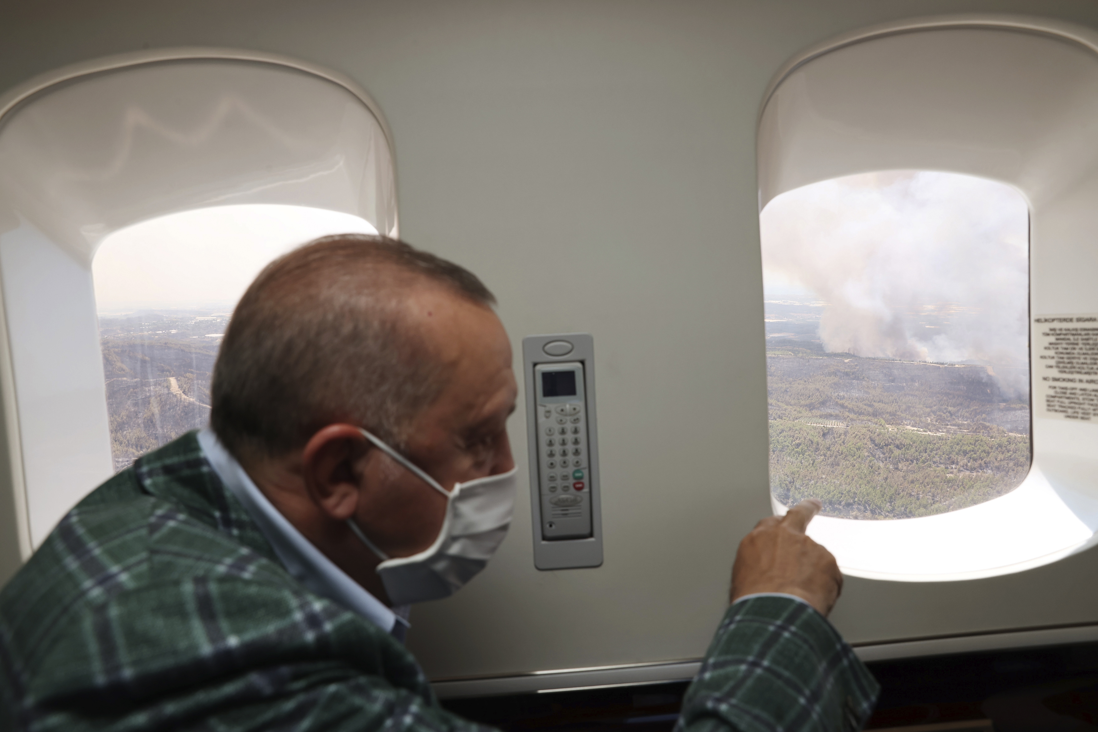 Turkey's President Recep Tayyip Erdogan watches from his plane the wildfires in Manavgat, Antalya, Turkey (Turkish Presidency via AP)