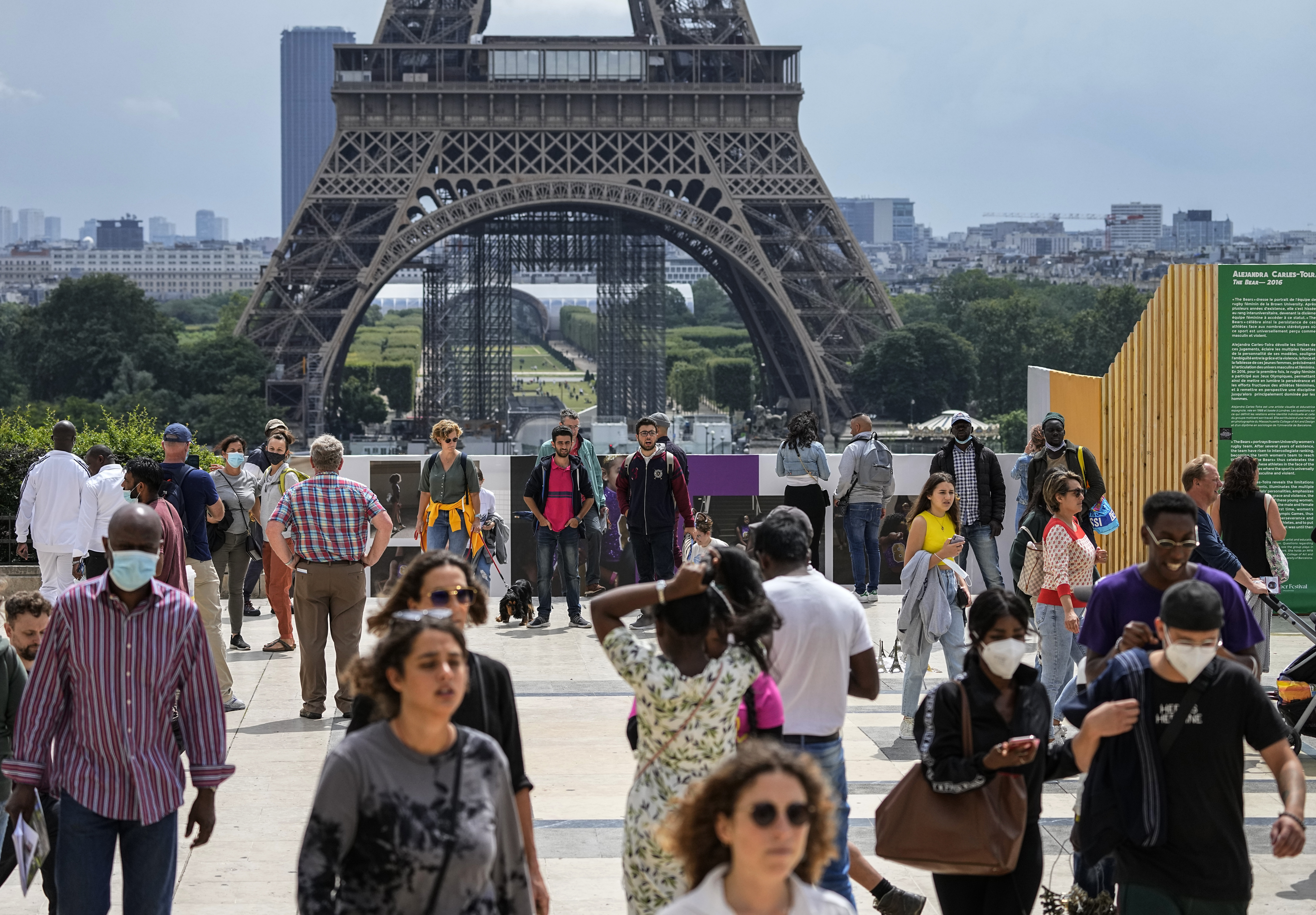People stroll near the Eiffel Tower in Paris