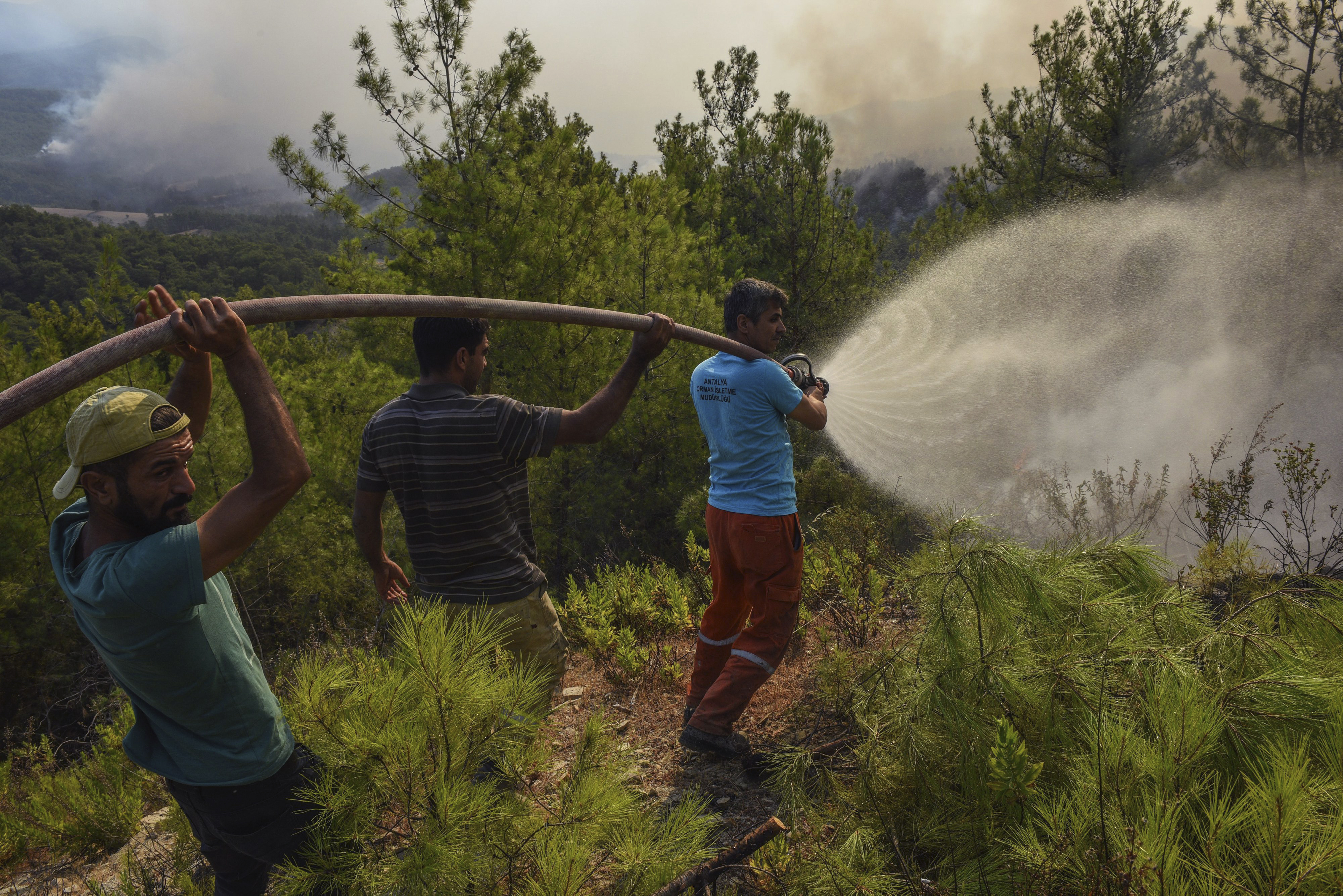 Villagers using a hose to fight fires in Turkey