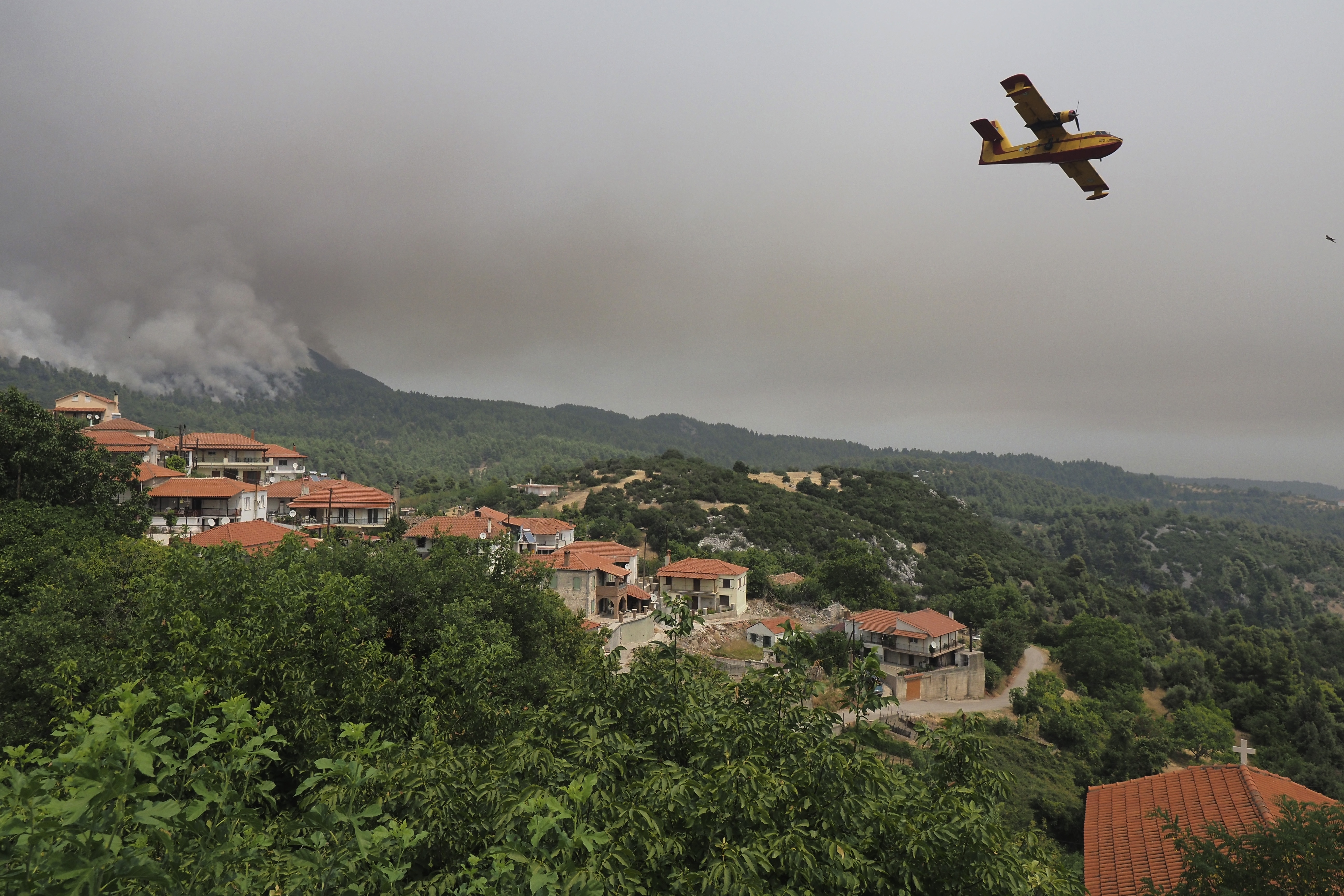 An aircraft operates over wildfires on the island of Evia 