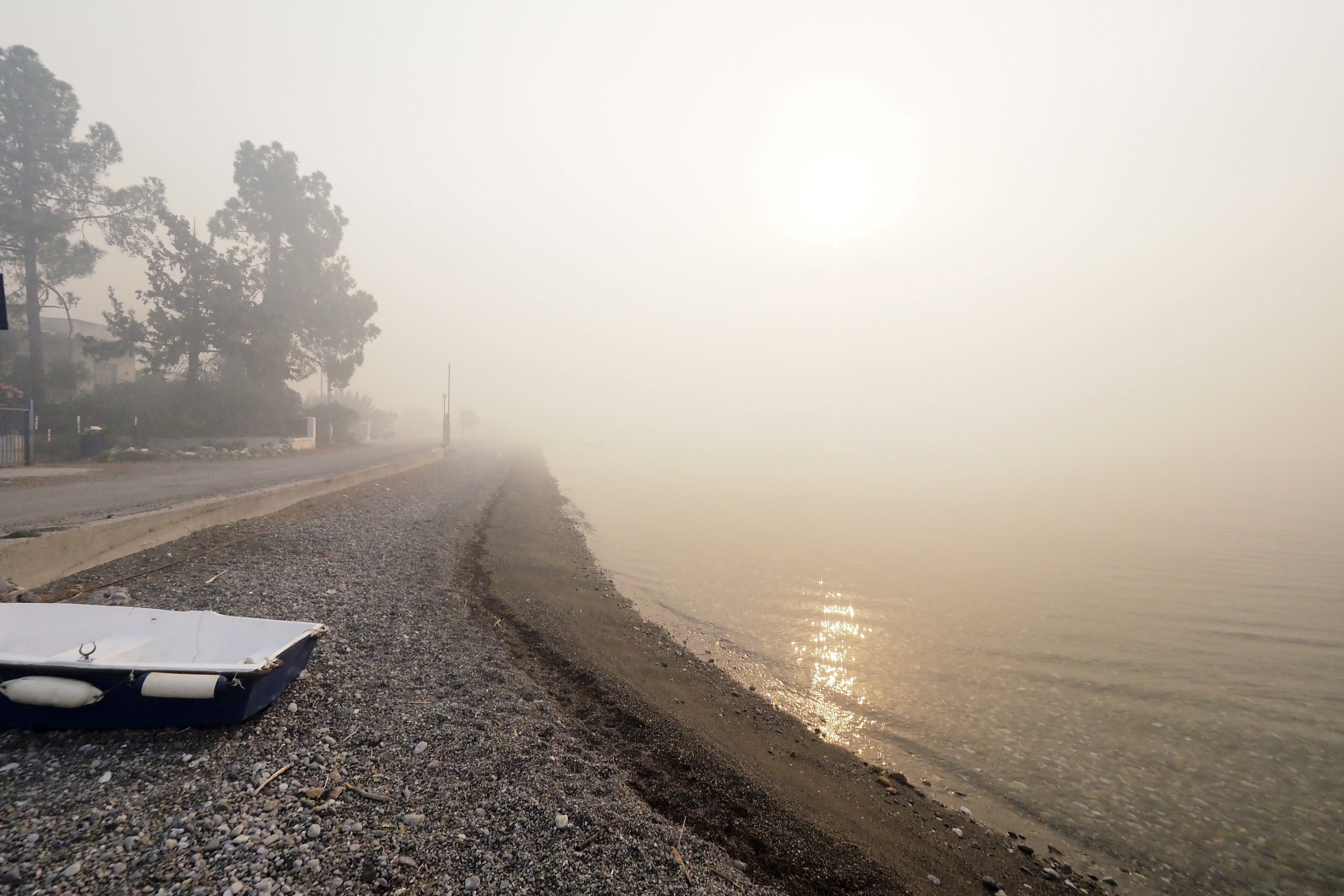 Smoke spreads over a beach during a wildfire in Limni village, Evia