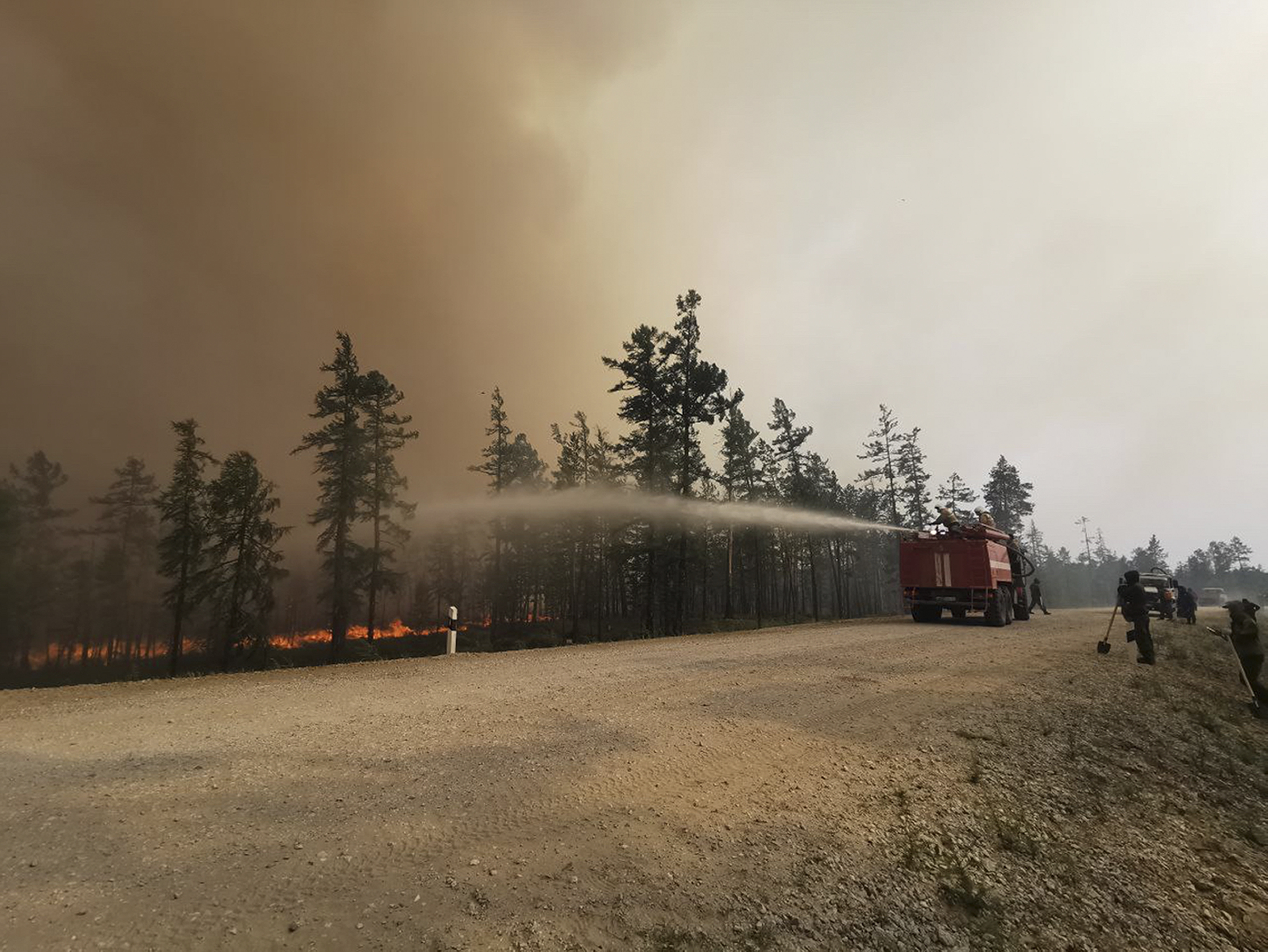 Firefighters work at the scene of a forest fire in Russia