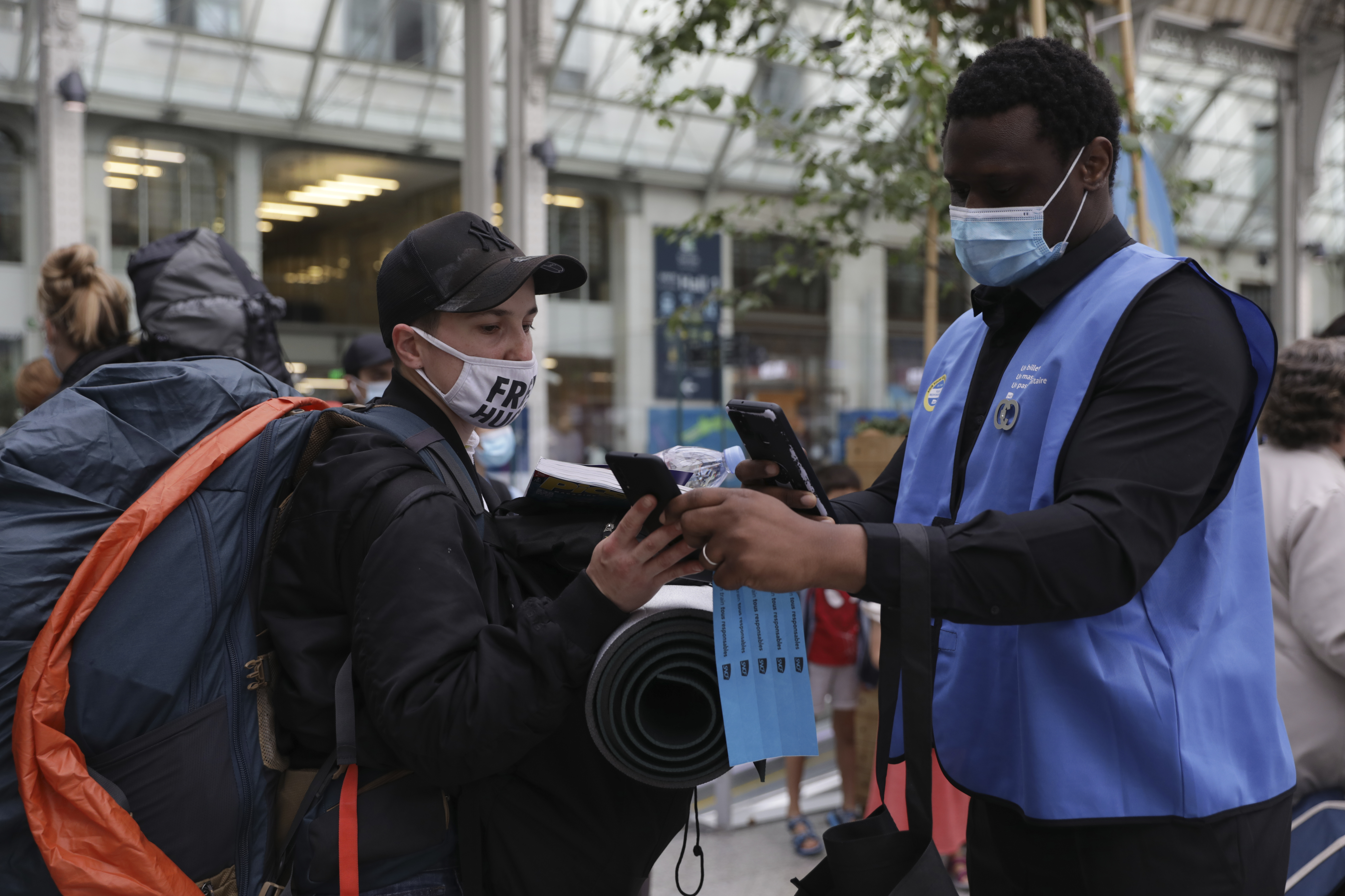 A railway employee checks the Covid-19 health pass that everyone in the country needs to enter cafes, trains and other venues at the Gare de Lyon train station in Paris 