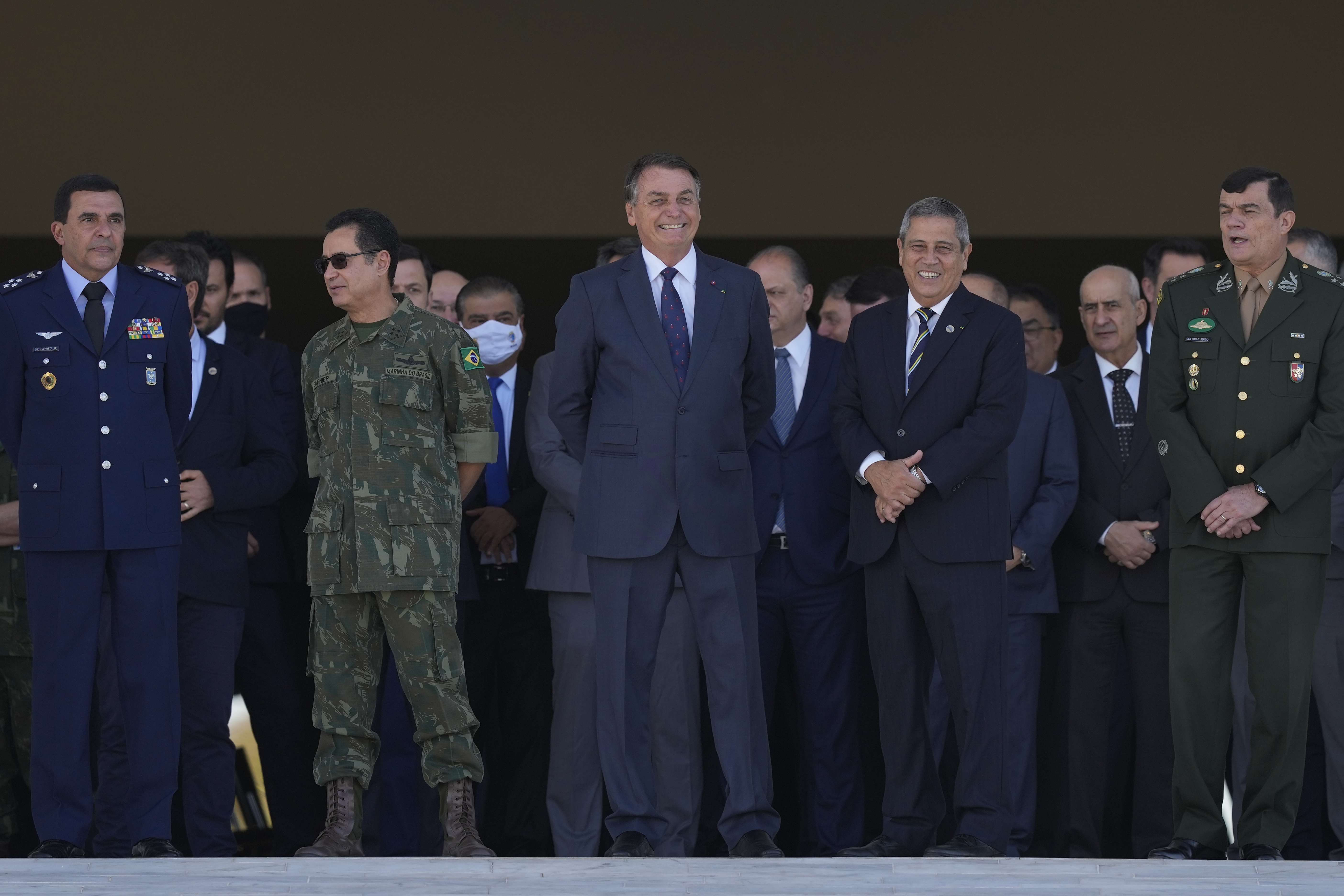 Jair Bolsonaro, centre,  watches the convoy pass by