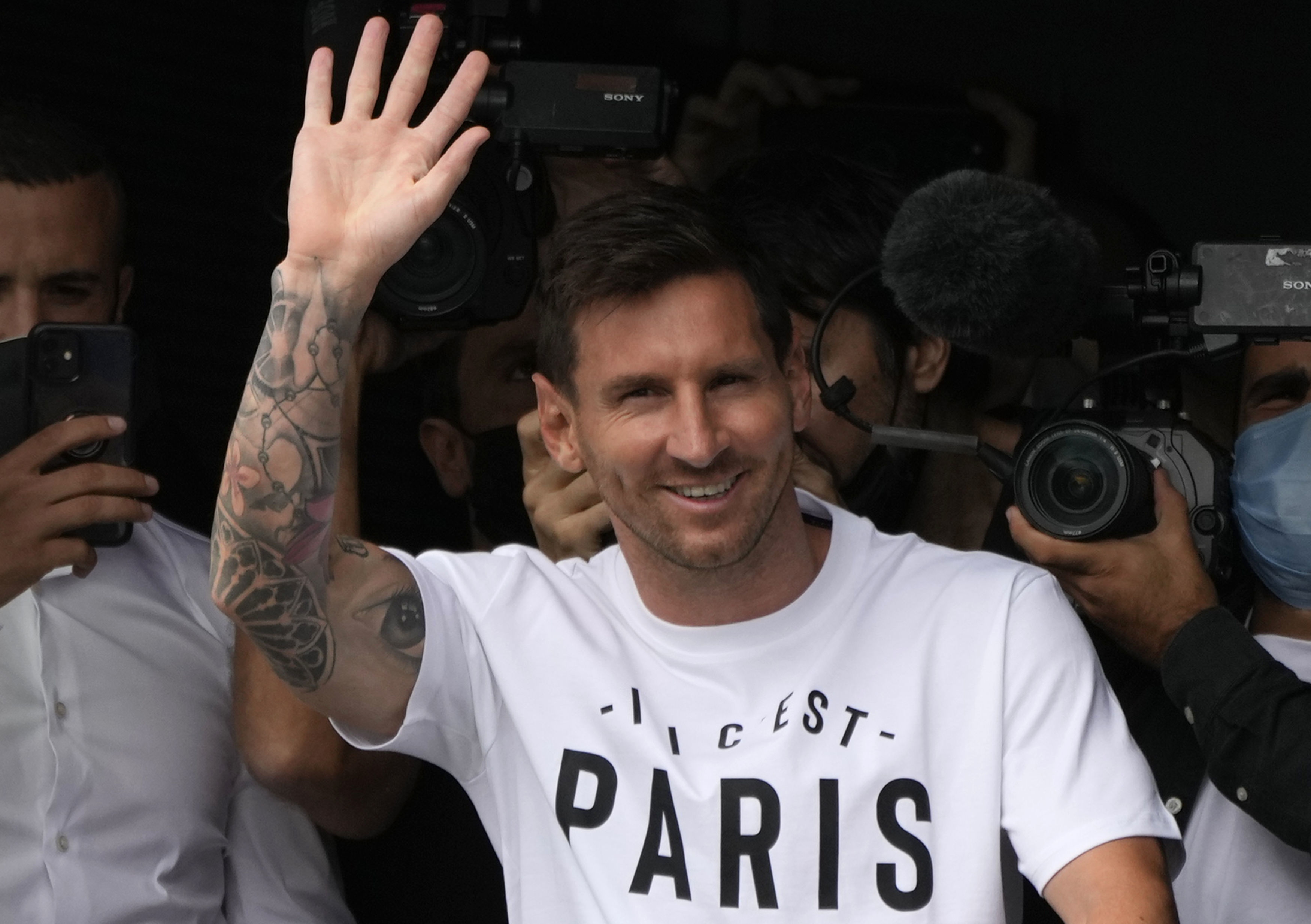 Lionel Messi, pictured waving after arriving at Le Bourget airport, north of Paris, has completed his move to Paris St Germain